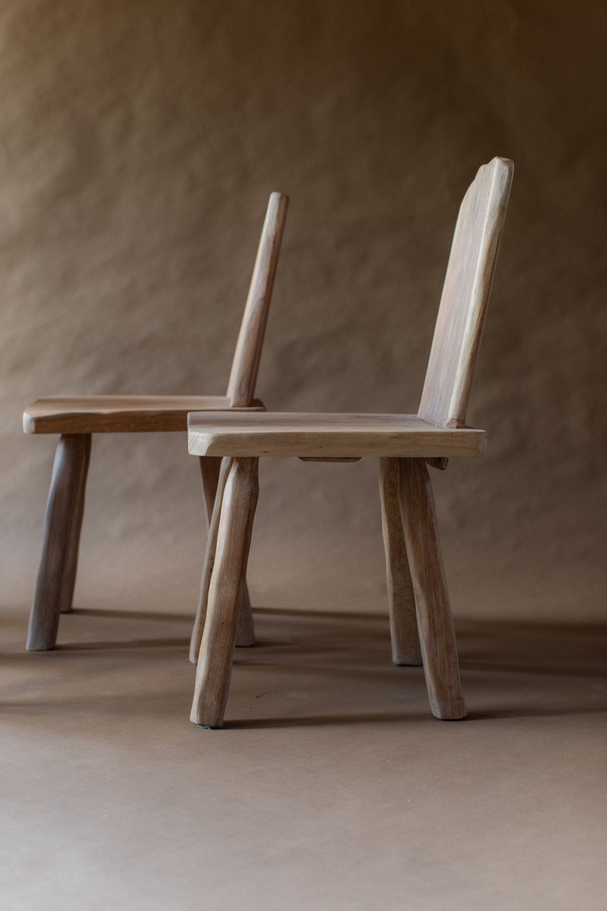 Two brutalist wooden chairs showing side profile detail