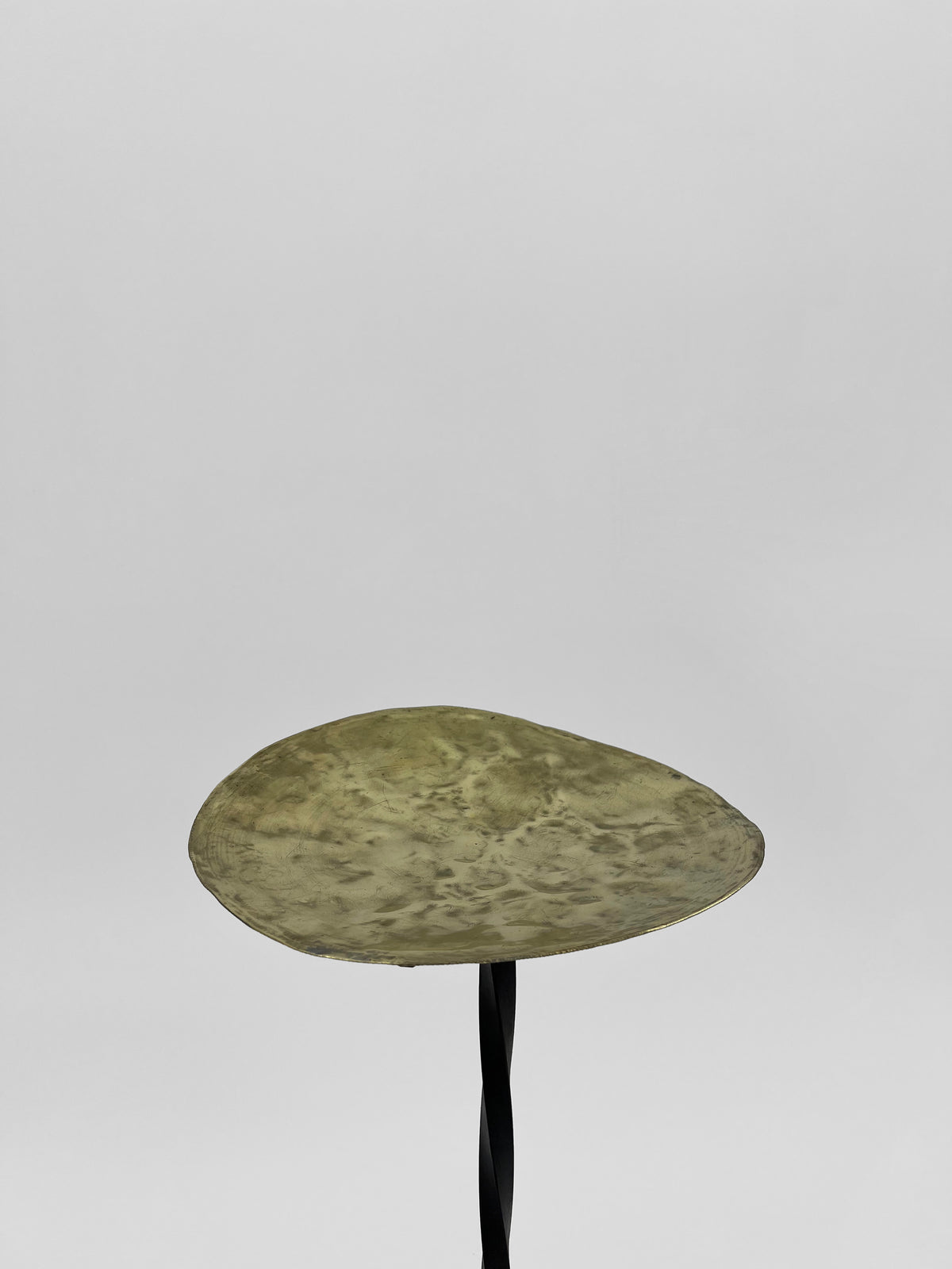 Brass candleholder with organic hammered surface by Camille Tan