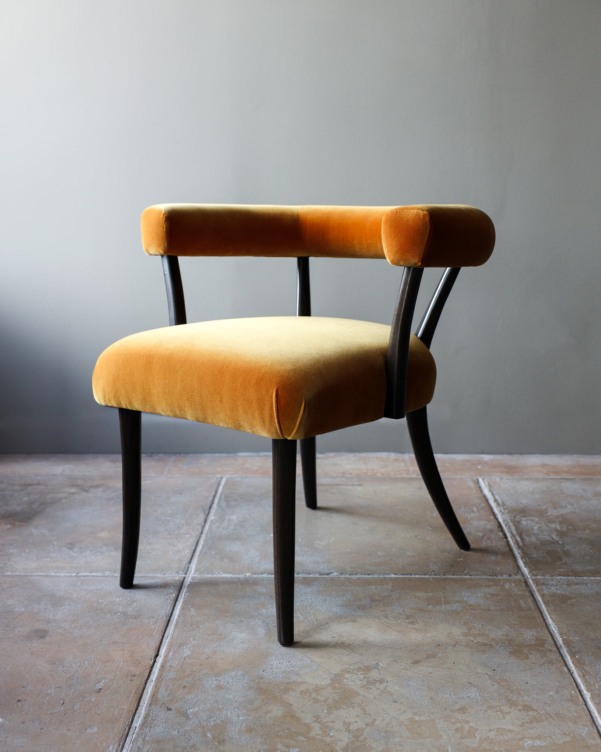 Orange velvet Josef dining chair with curved black legs detail