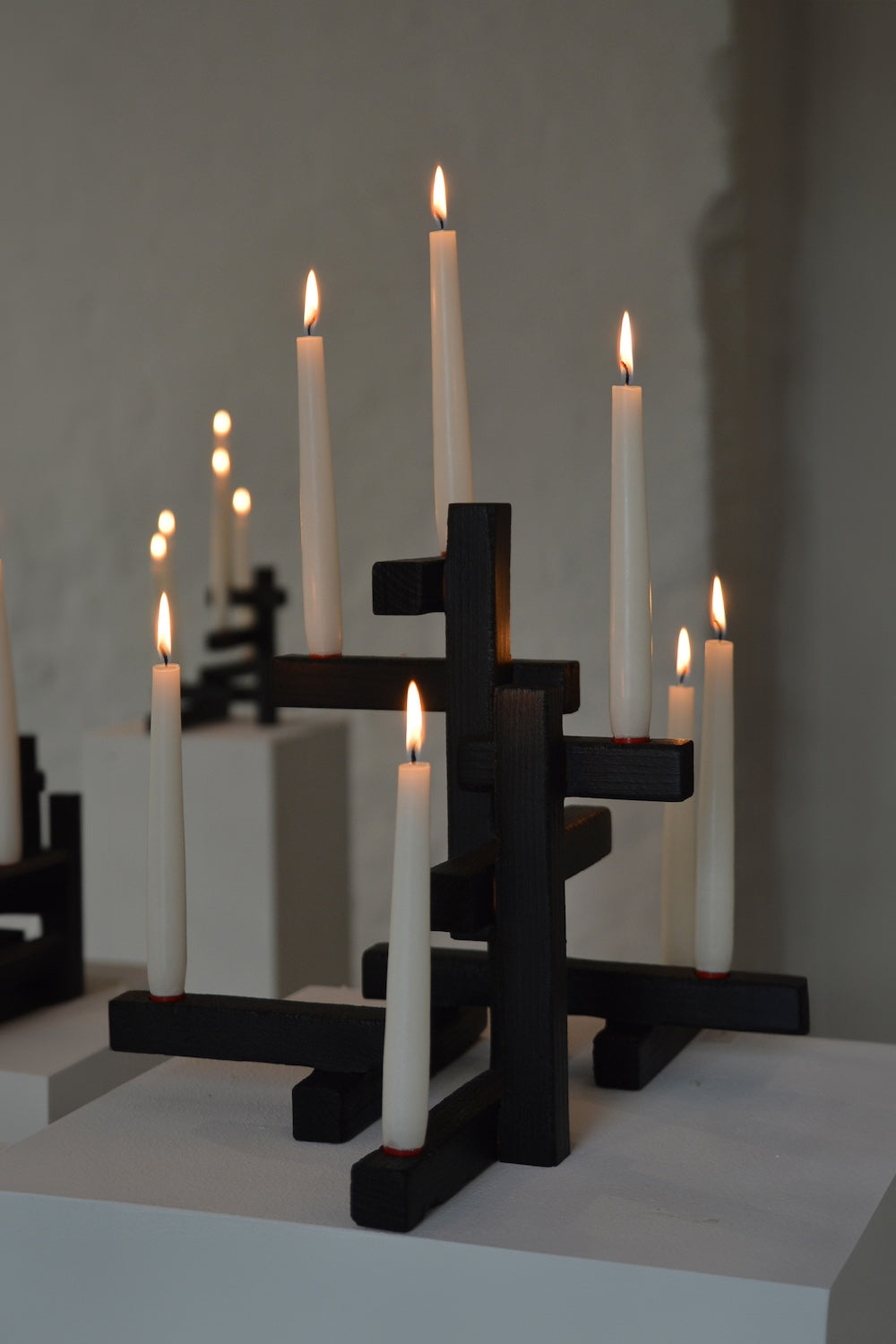 Black geometric Tetris 7 candleholder with lit white candles