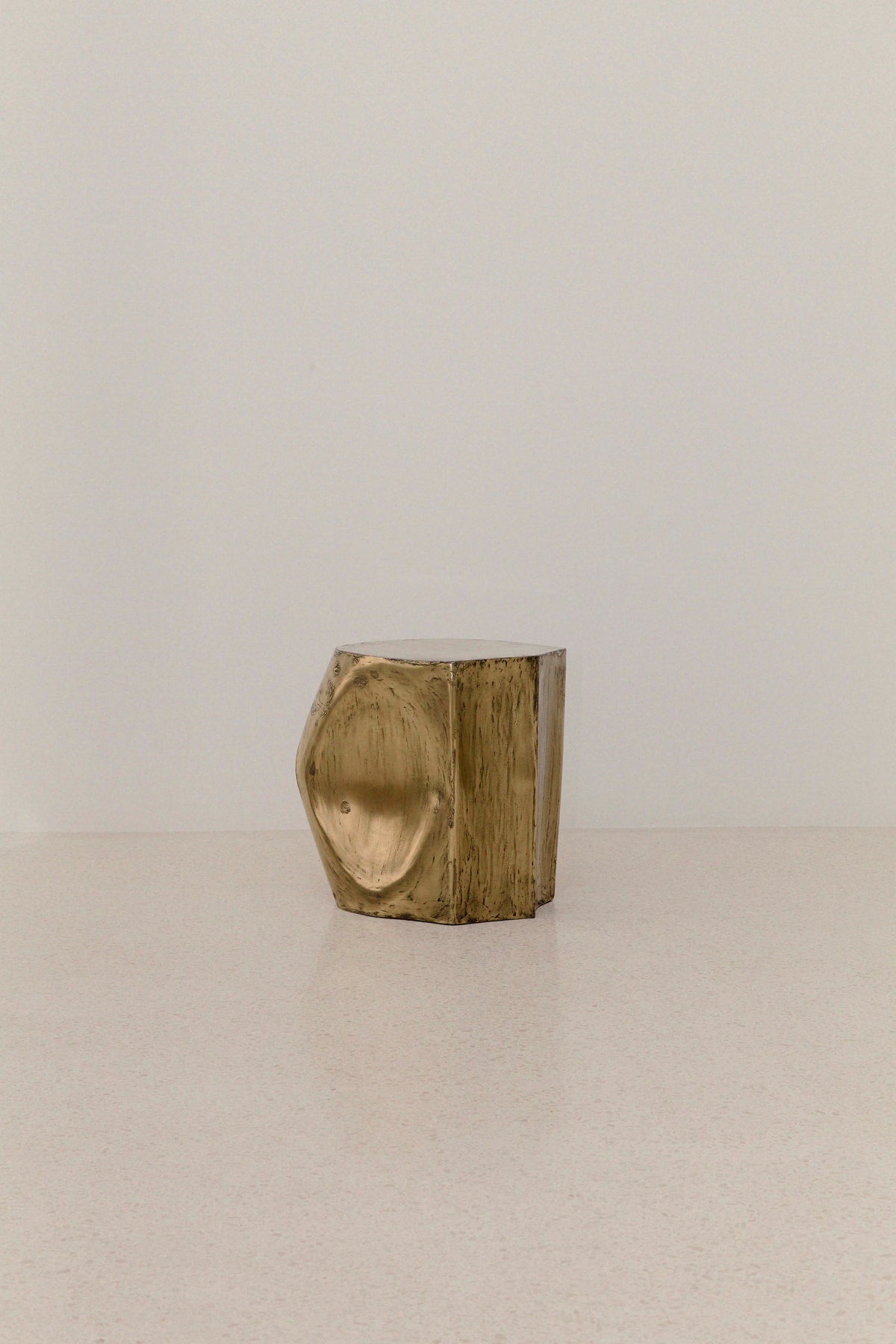 ROCHER SMALL TABLE IN POLISHED BRASS RESIN — top view on light surface
