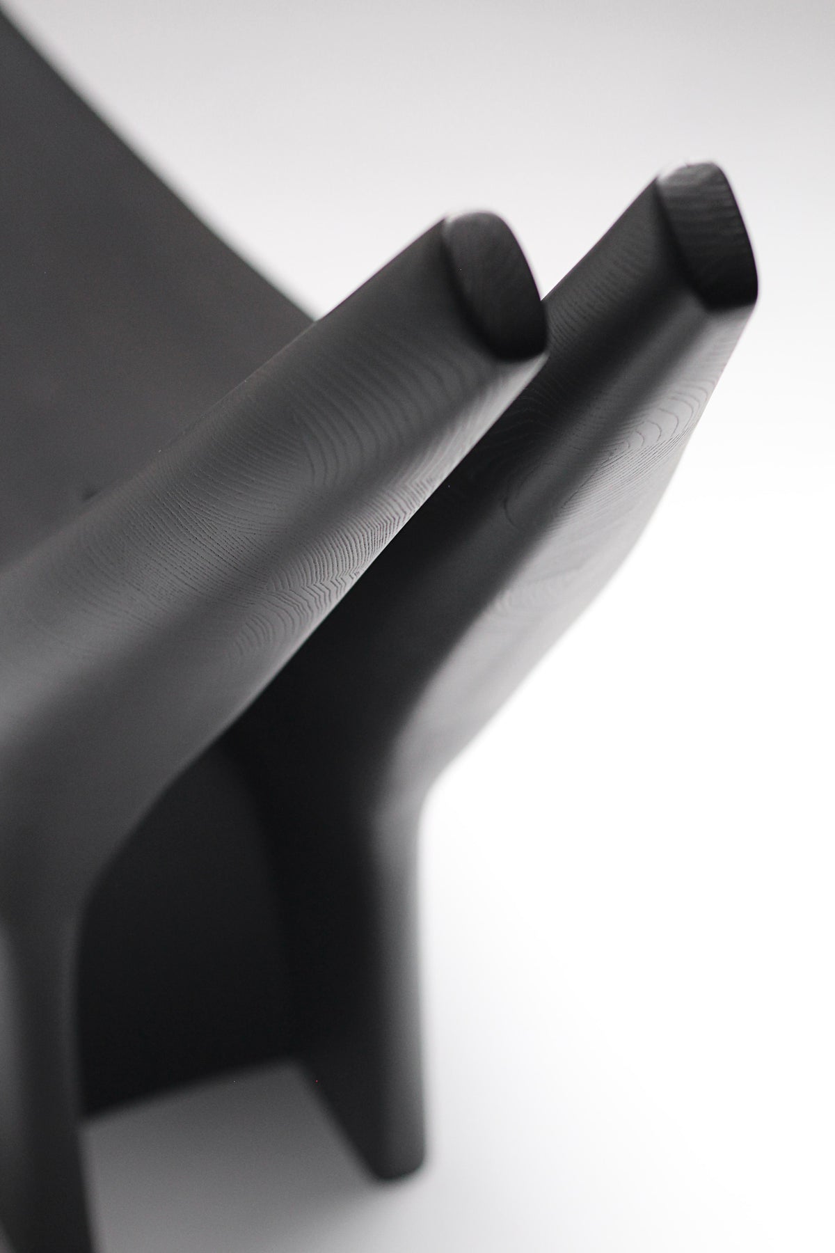 Dym Lounge Chair — back view highlighting smooth black wood finish
