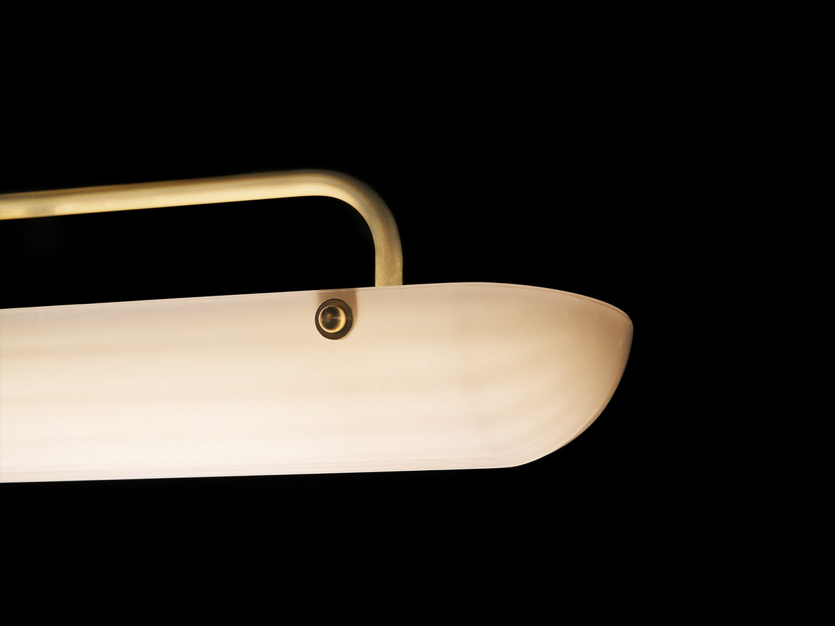 Close-up detail of Eos pendant lamp's quartz glass shade and brass handle