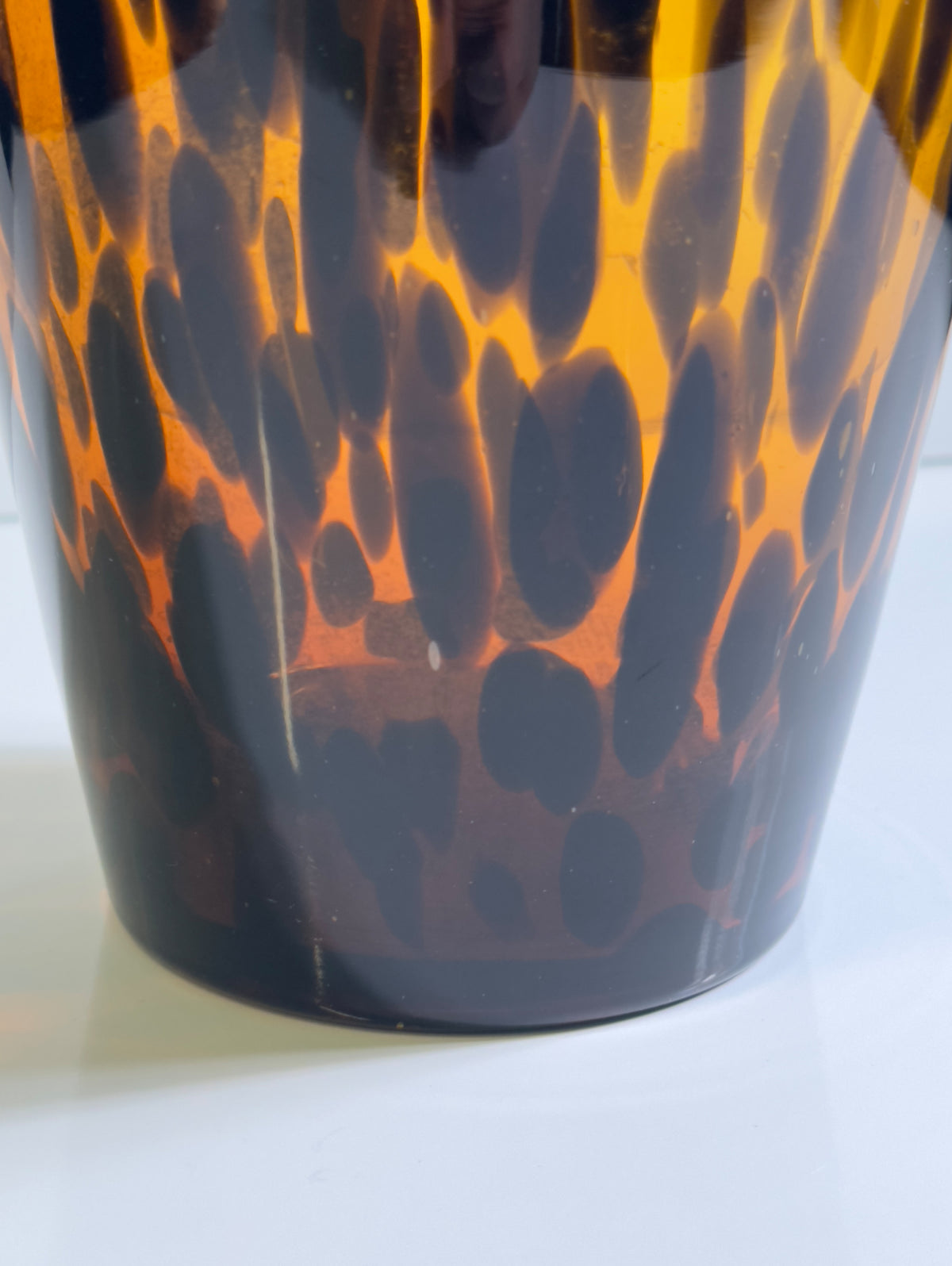 Close-up detail of Murano tortoise glass vase showing amber flames