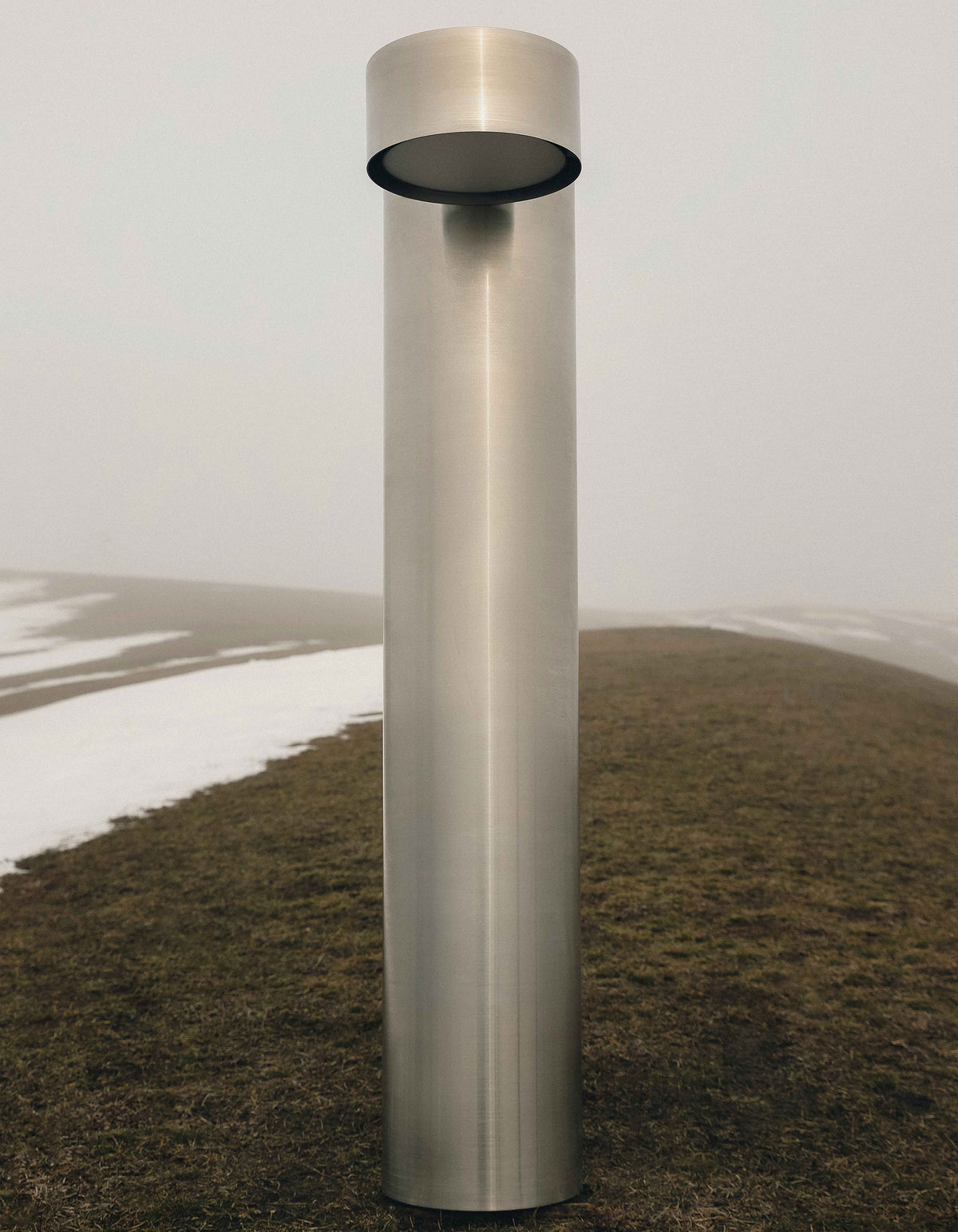 X floor lamp — back view showing brushed metal finish outdoors