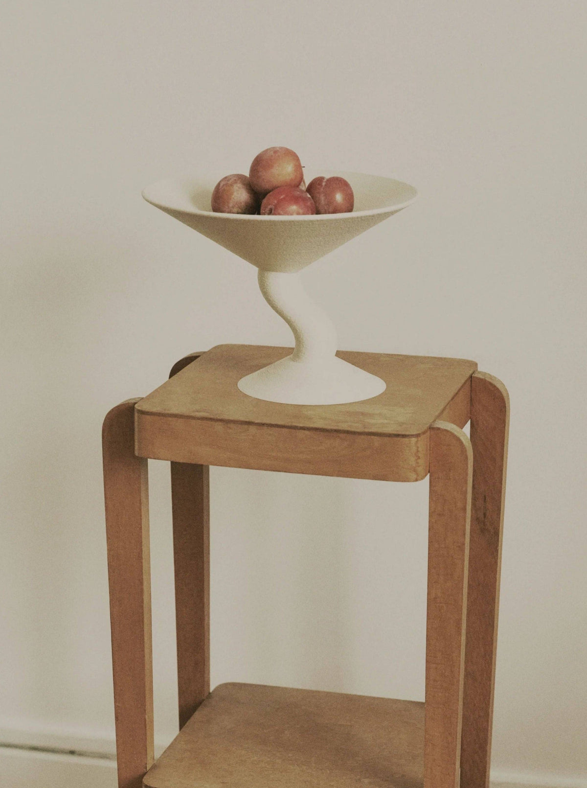 Wavy Fruit Stand — close-up of white ceramic bowl on wooden table