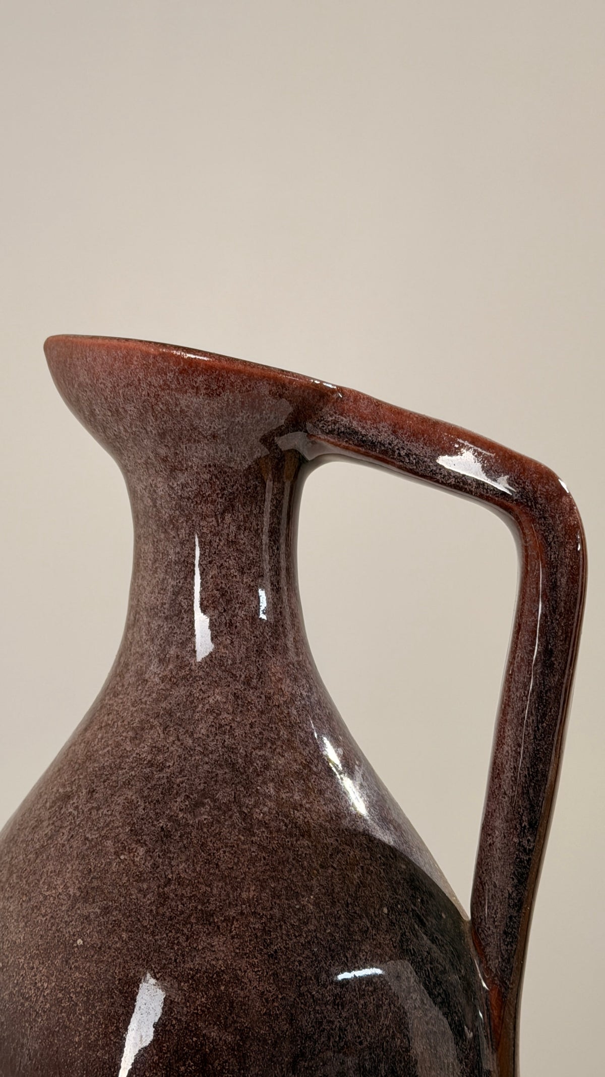 Ceramic pitcher by the Accolay potters, France, circa 1960 — close-up of glossy brown ceramic surface