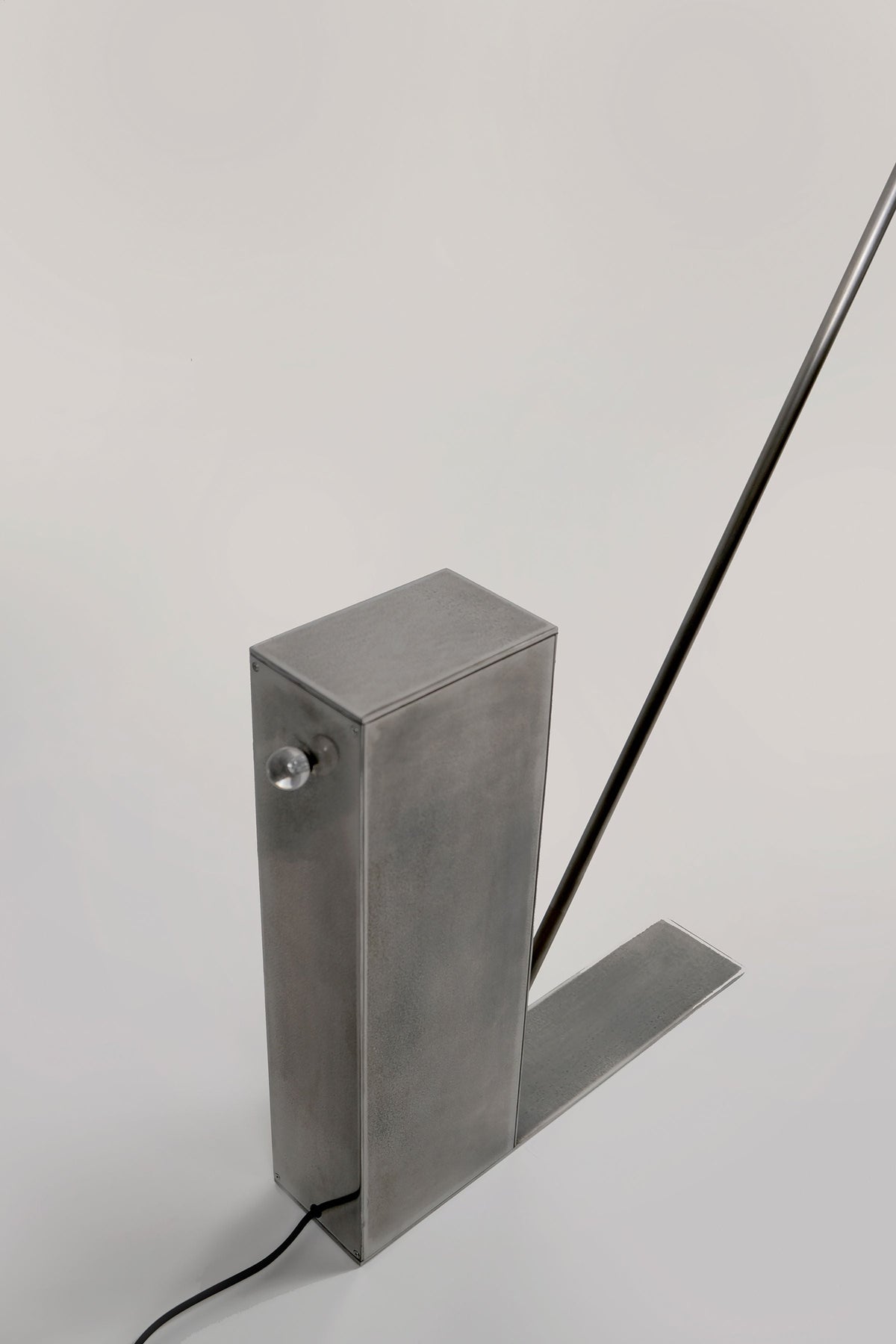 Modern steel floor lamp with angled rod and rectangular base