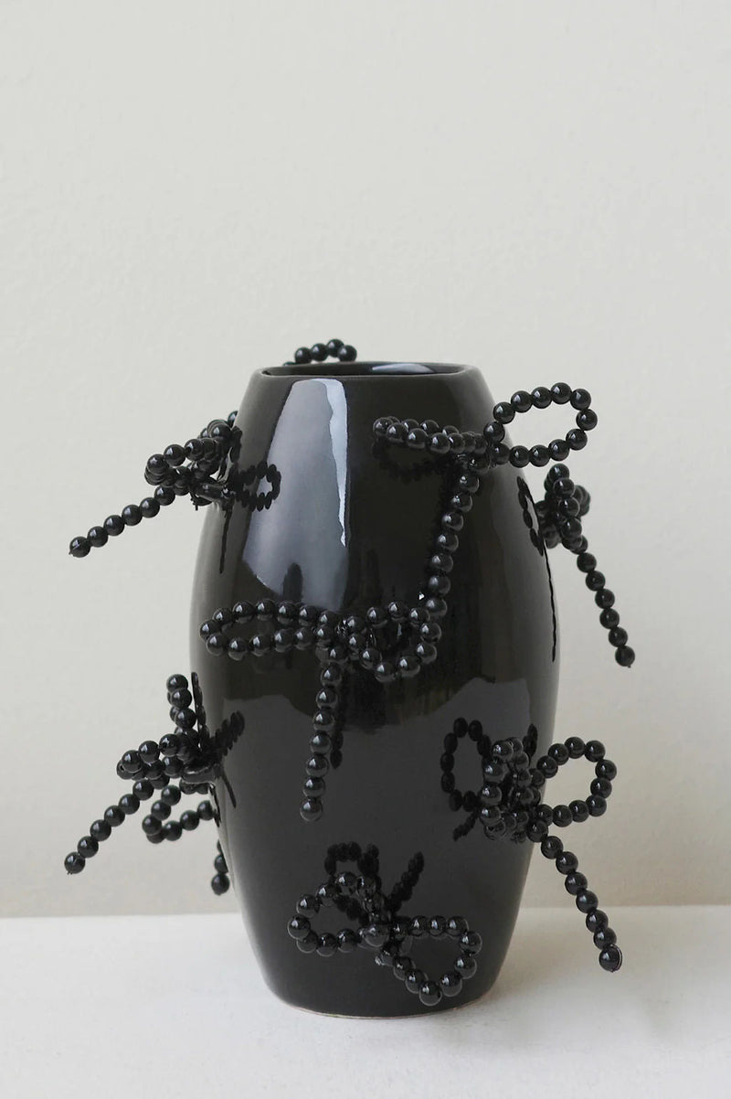 The Pearly Pearl - Small Vase In Gloss Black by Completedworks features sculptural ceramics adorned with beaded dragonfly motifs crafted from small black beads, set against a plain light background.
