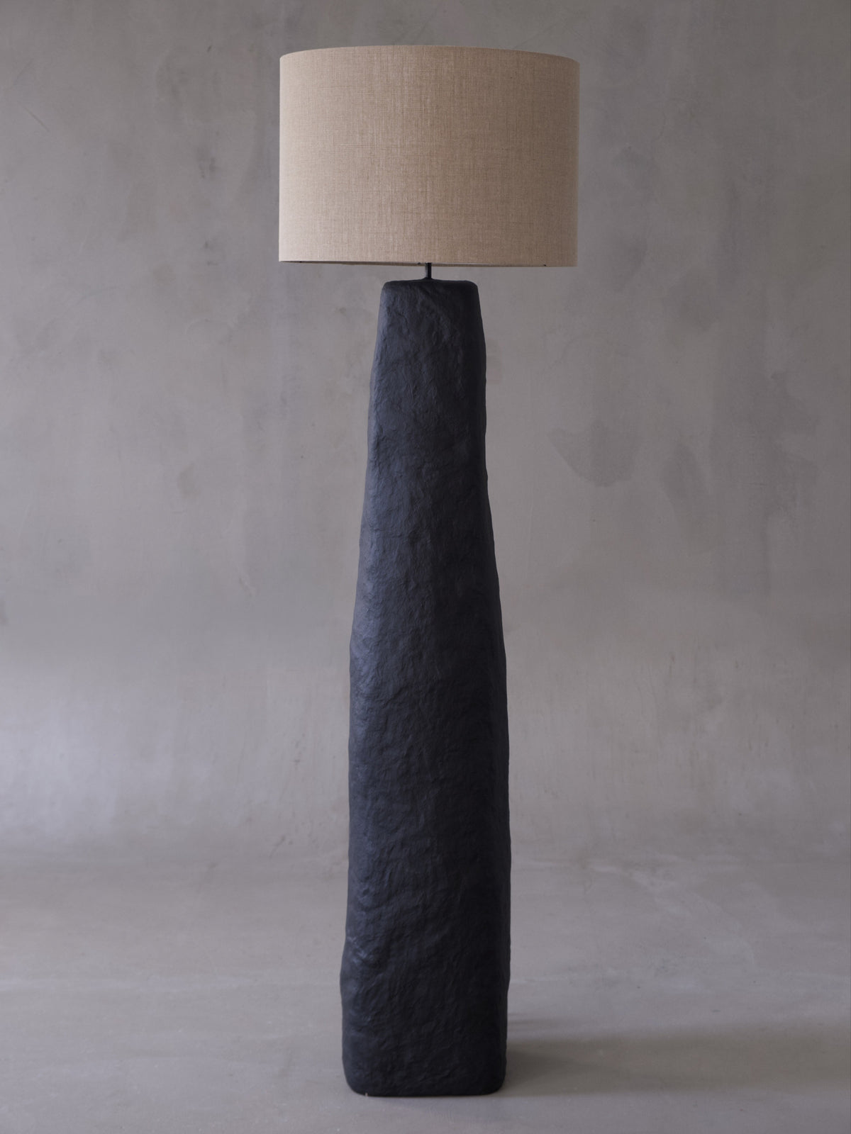 Skelia Sculptural Floor Lamp — side angle showing textured black base and beige shade