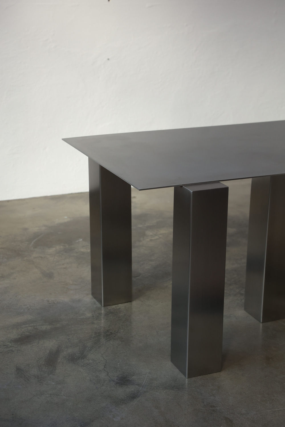 Atrium Desk — side angle showing brushed metal surface and legs