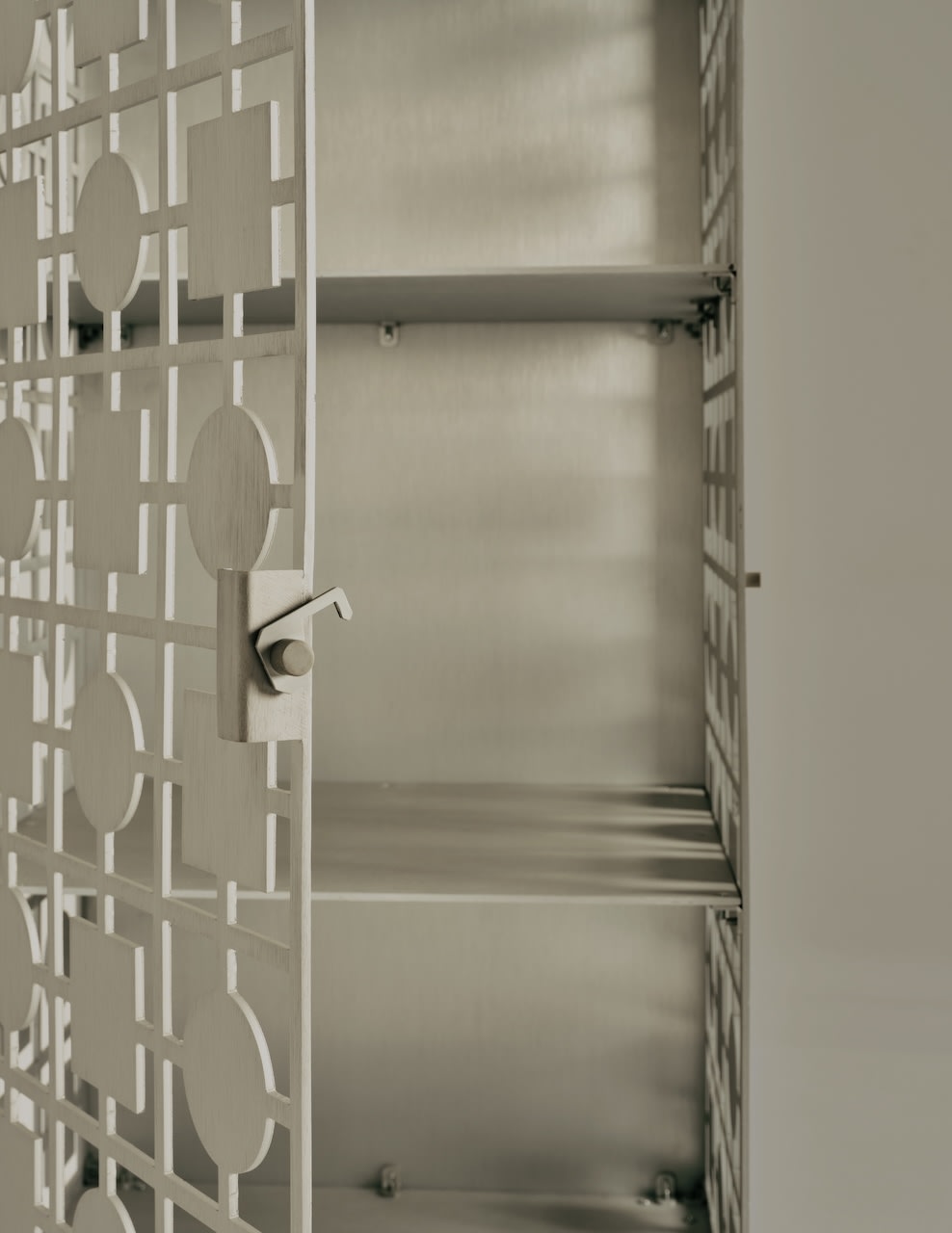 Sona cabinet interior detail showing adjustable shelves and geometric door pattern