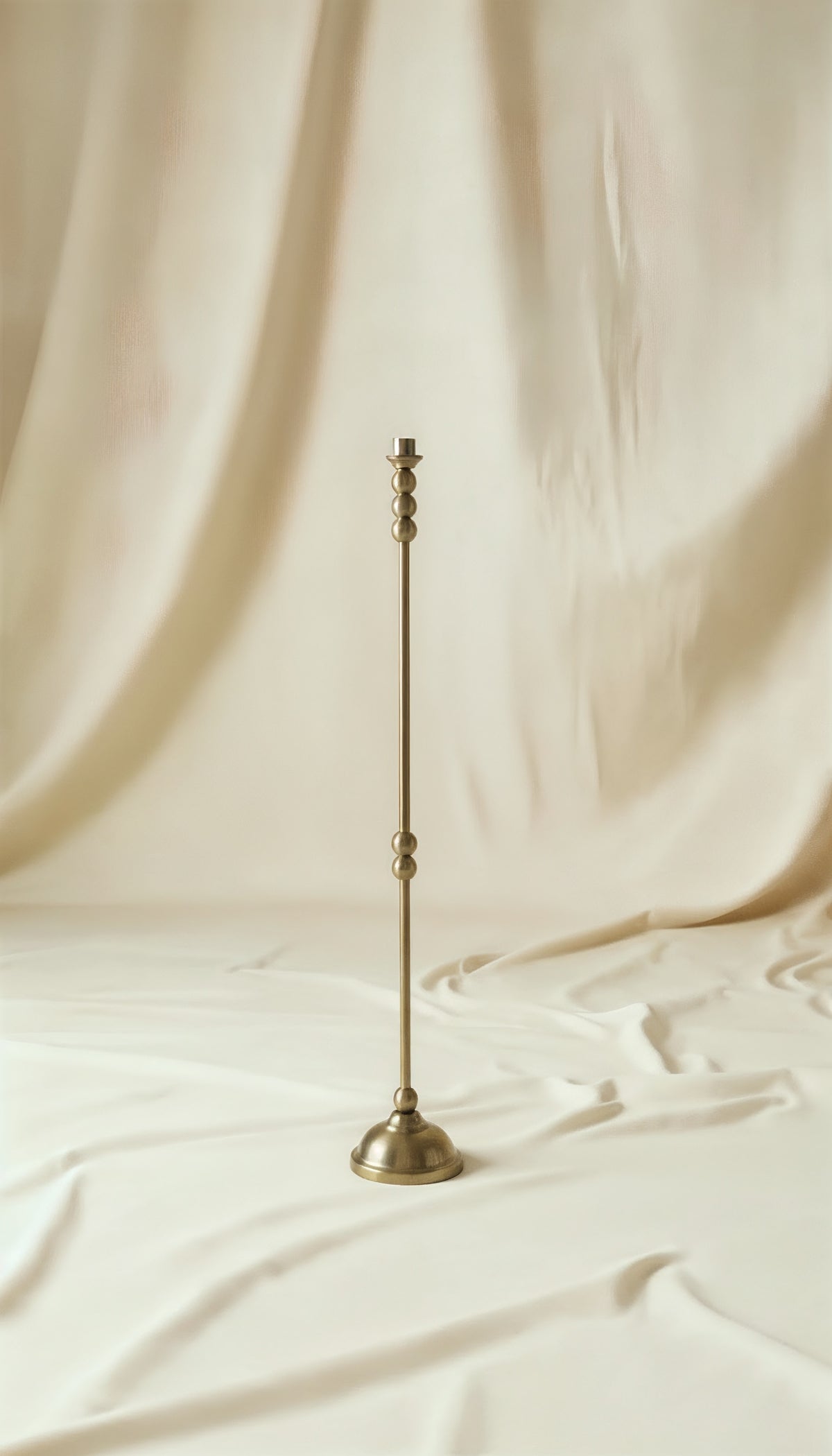 ASHA I – Brushed Brass Sculptural Candlestick Set — standing on soft fabric backdrop