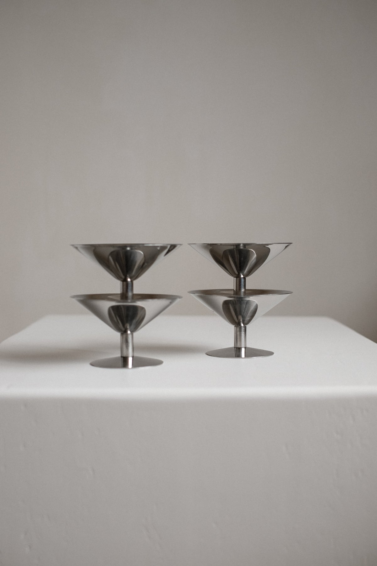 Set of Four Ice Coupes — close-up of polished metal surface on white pedestal