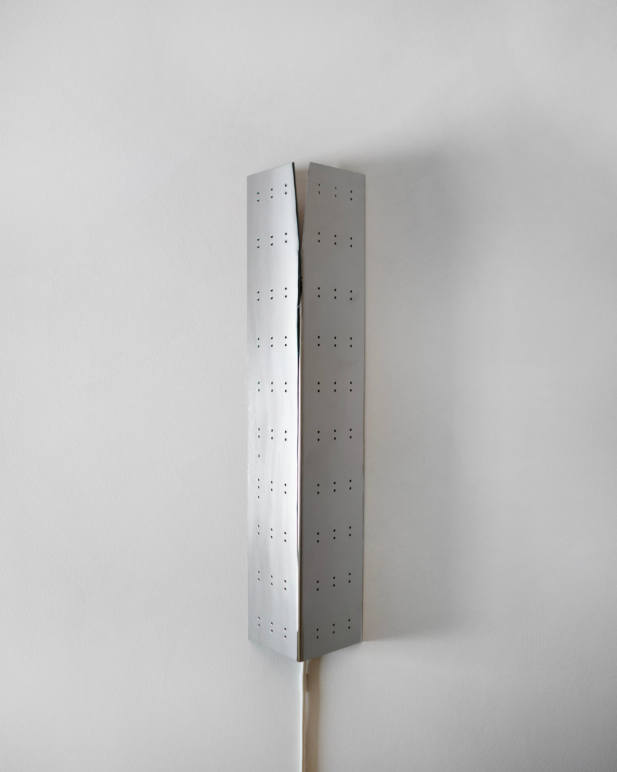 May Wall Lamp - Polished Steel — back view against white wall