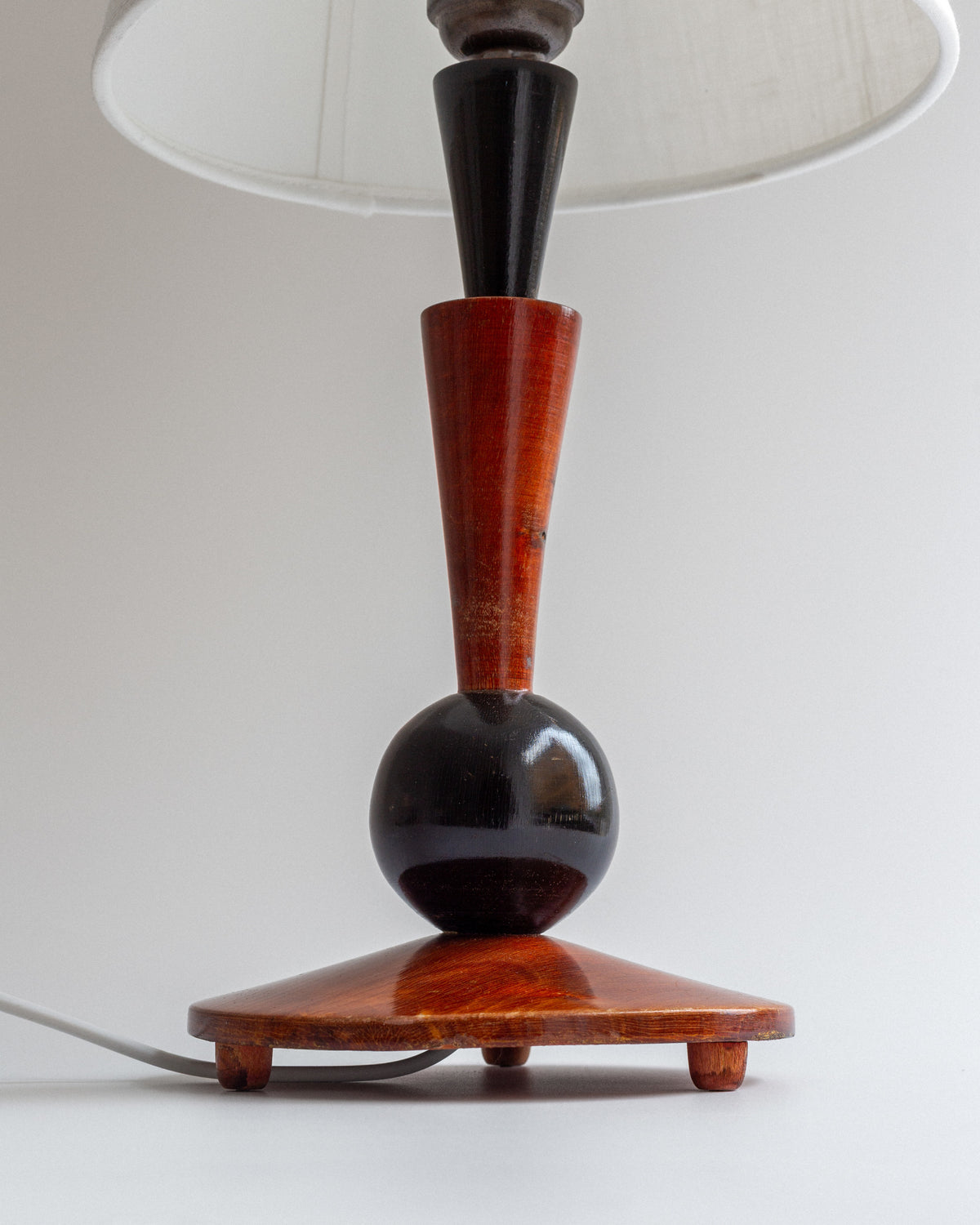 Art Deco wooden table lamp with geometric base and white shade detail