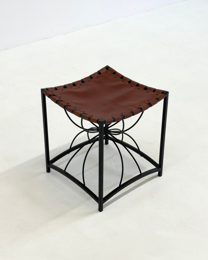 Elegant vintage French stool with black metal and brown leather — in context