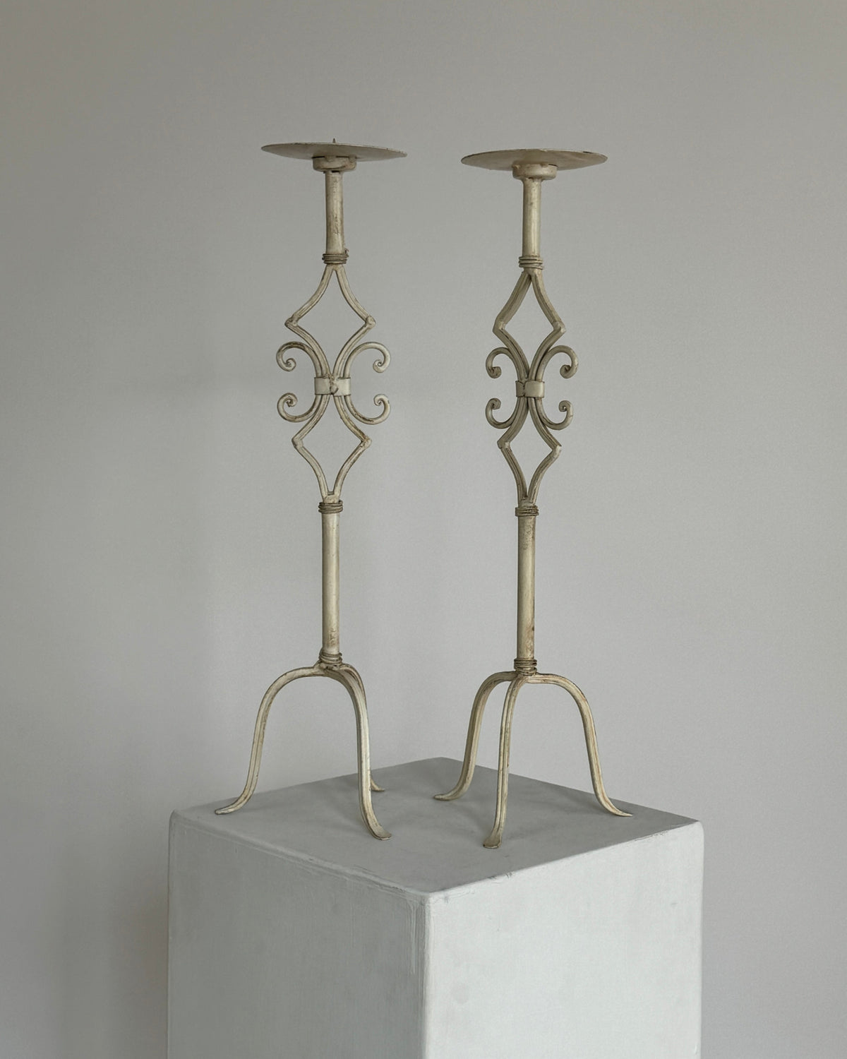 Antique white metal candleholders with ornate scrollwork design
