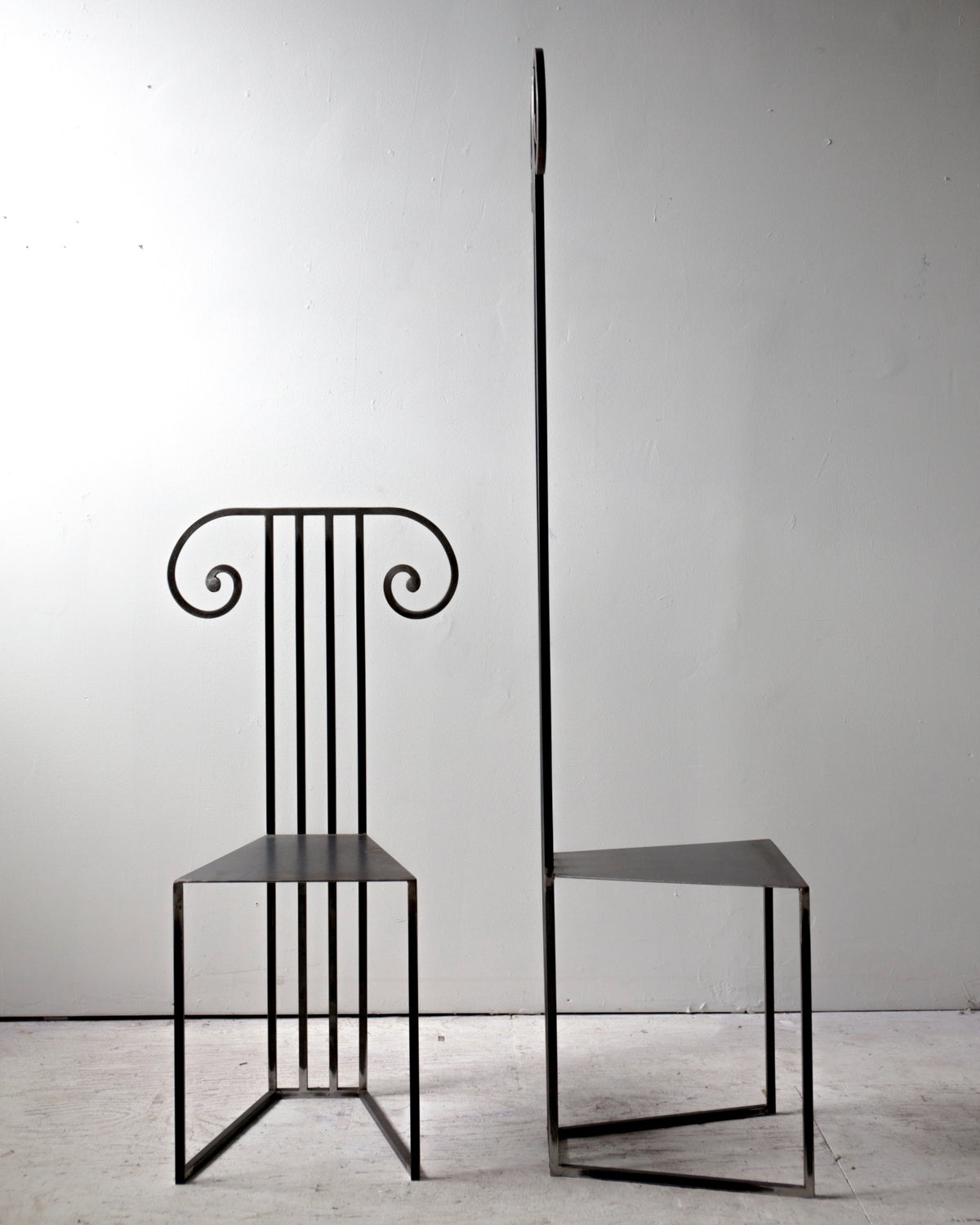 Modern black metal chair with decorative scrollwork backrest detail
