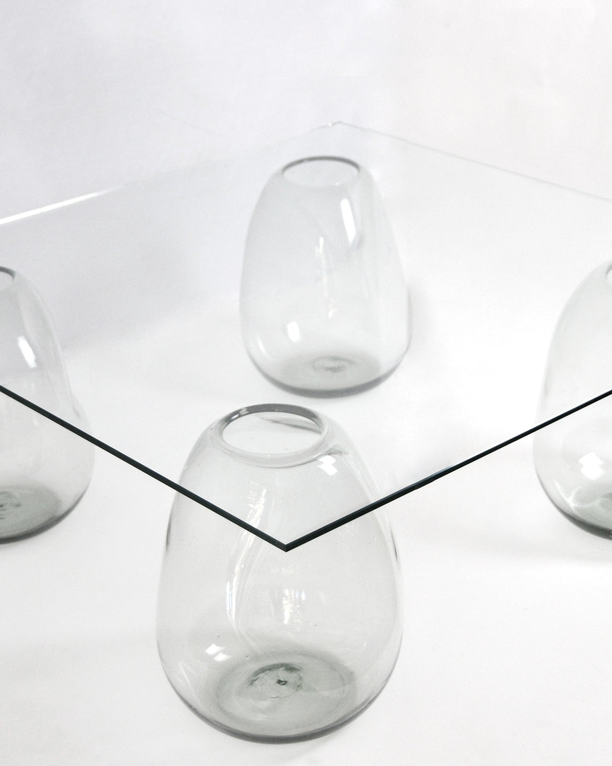 Close-up detail of transparent glass bubble legs supporting table