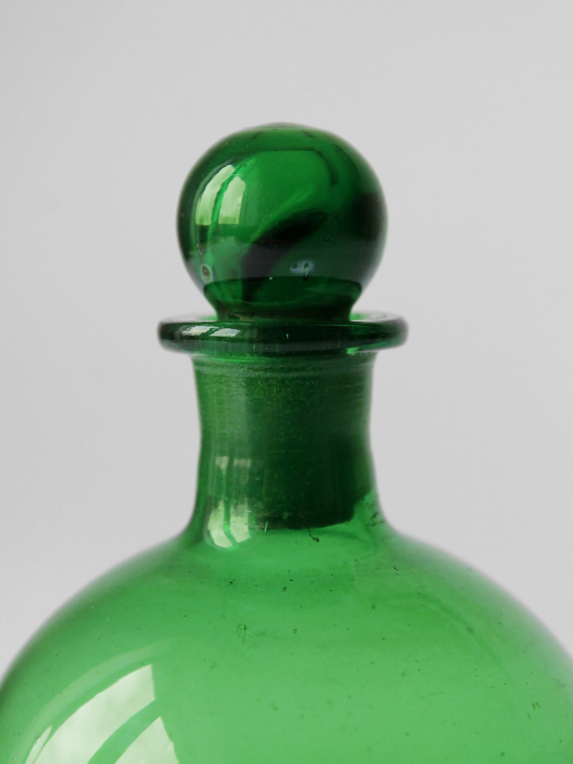 Emerald green glass perfume bottle stopper detail closeup