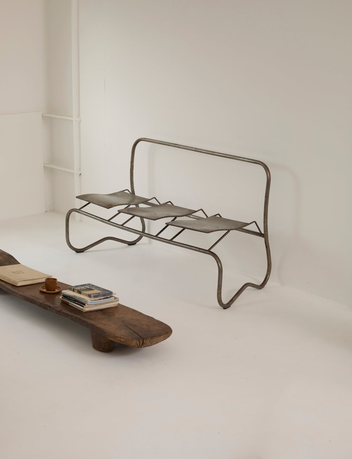 Unique Signed Artist Bench / Settee in Metal — side view of metal frame in minimalist setting