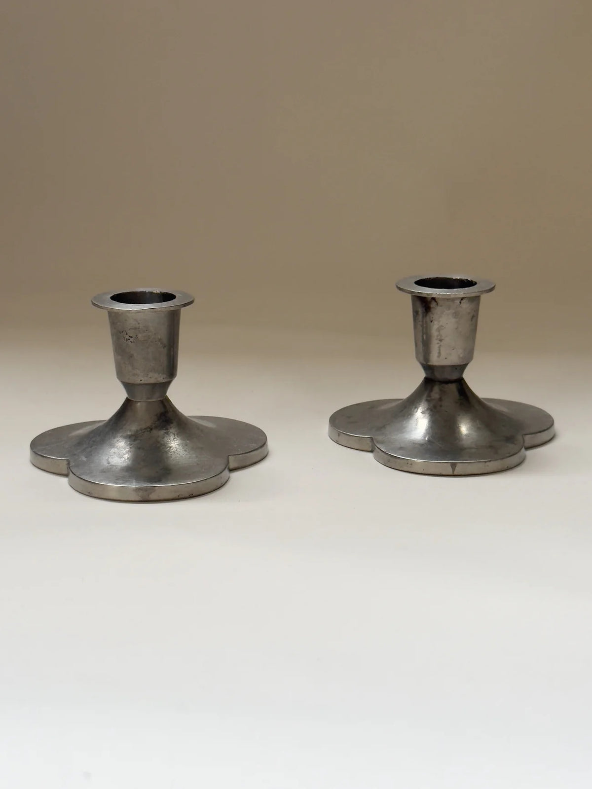 Pair of Pewter Candlesticks by Just Andersen — front view on neutral background