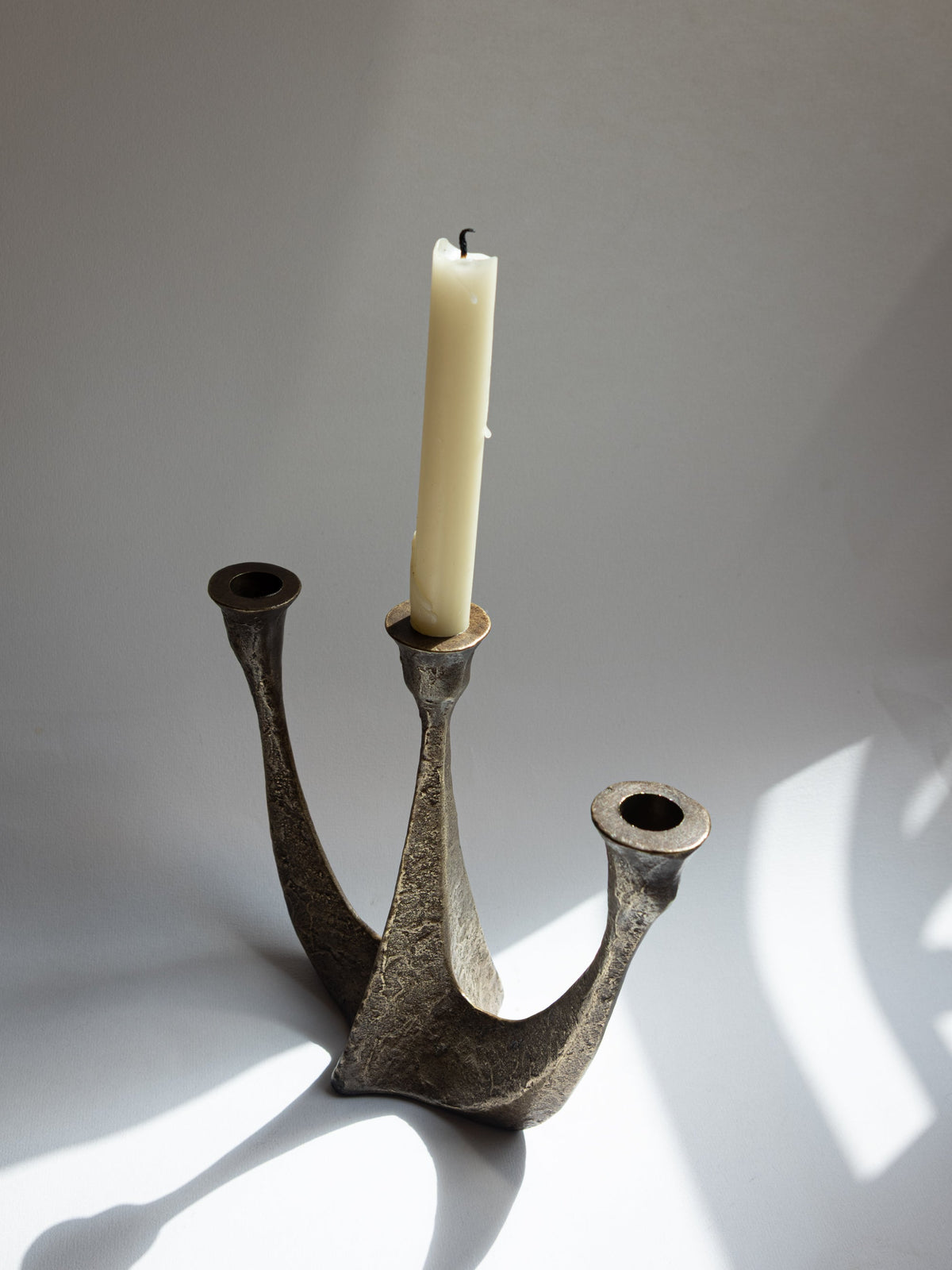 Brutalist bronze candelabra with single lit candle, Germany 1970s