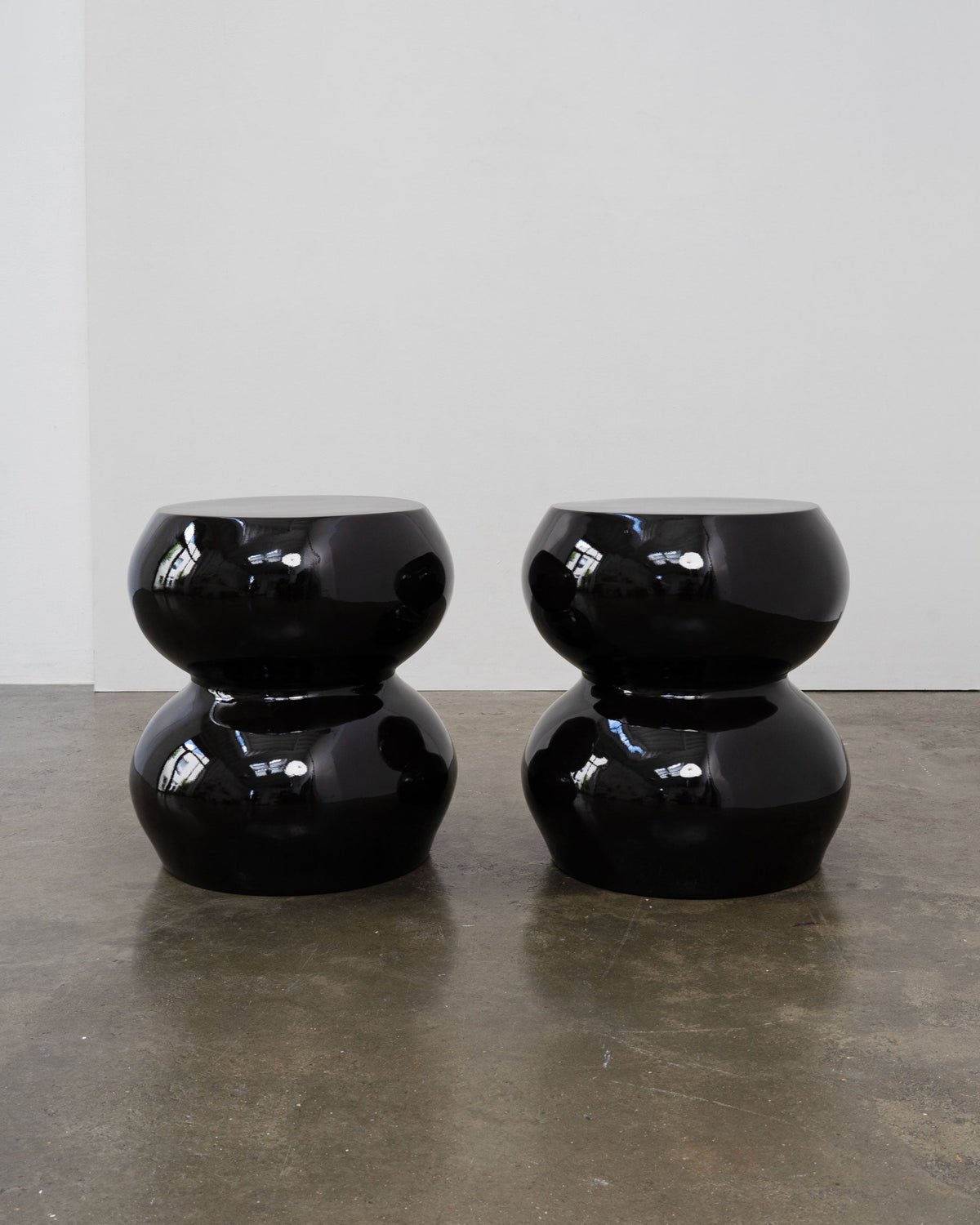 Pair of glossy black sculptural stools double stacking design