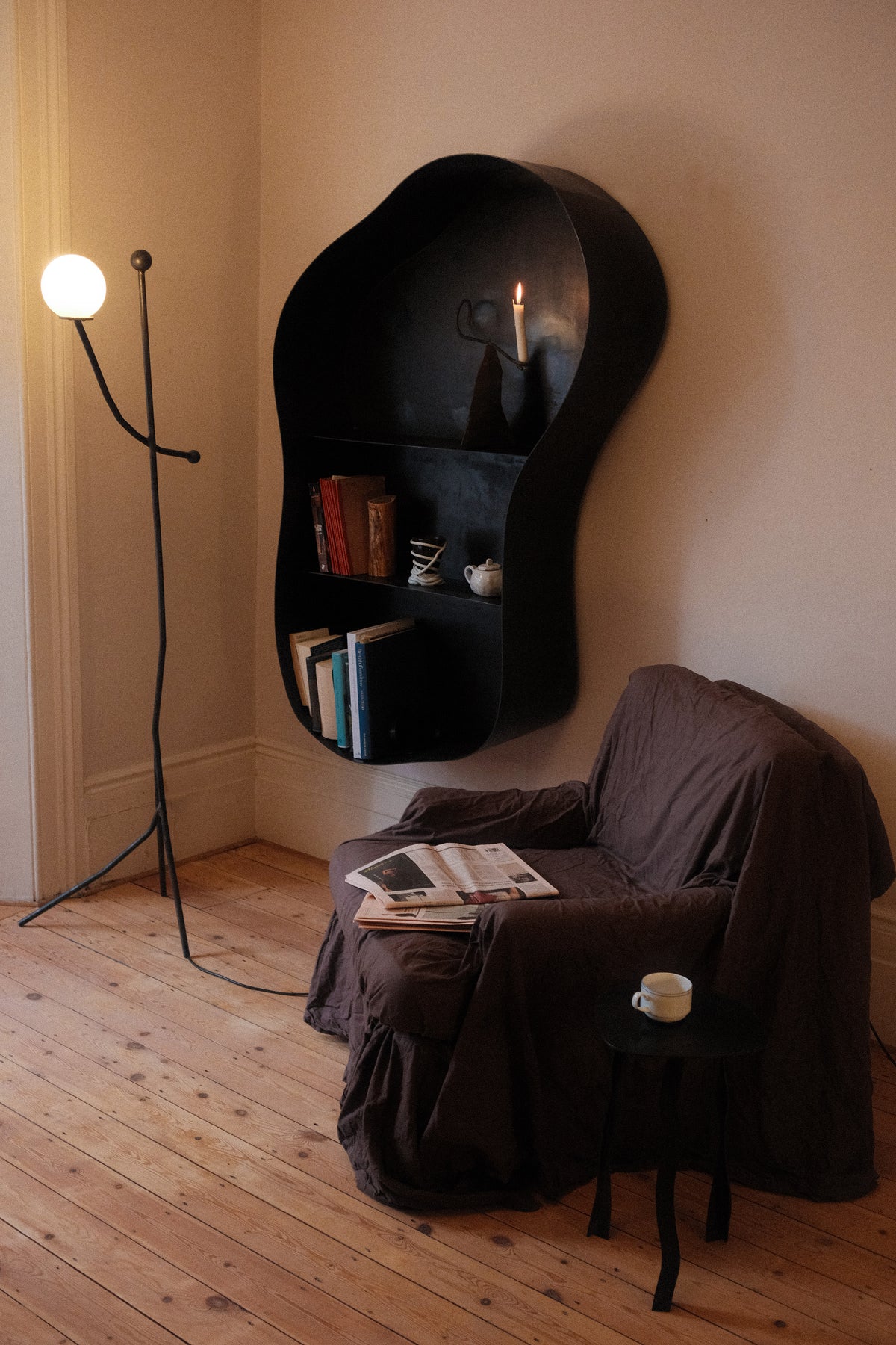 Modern black floor lamp with spherical light in cozy reading nook