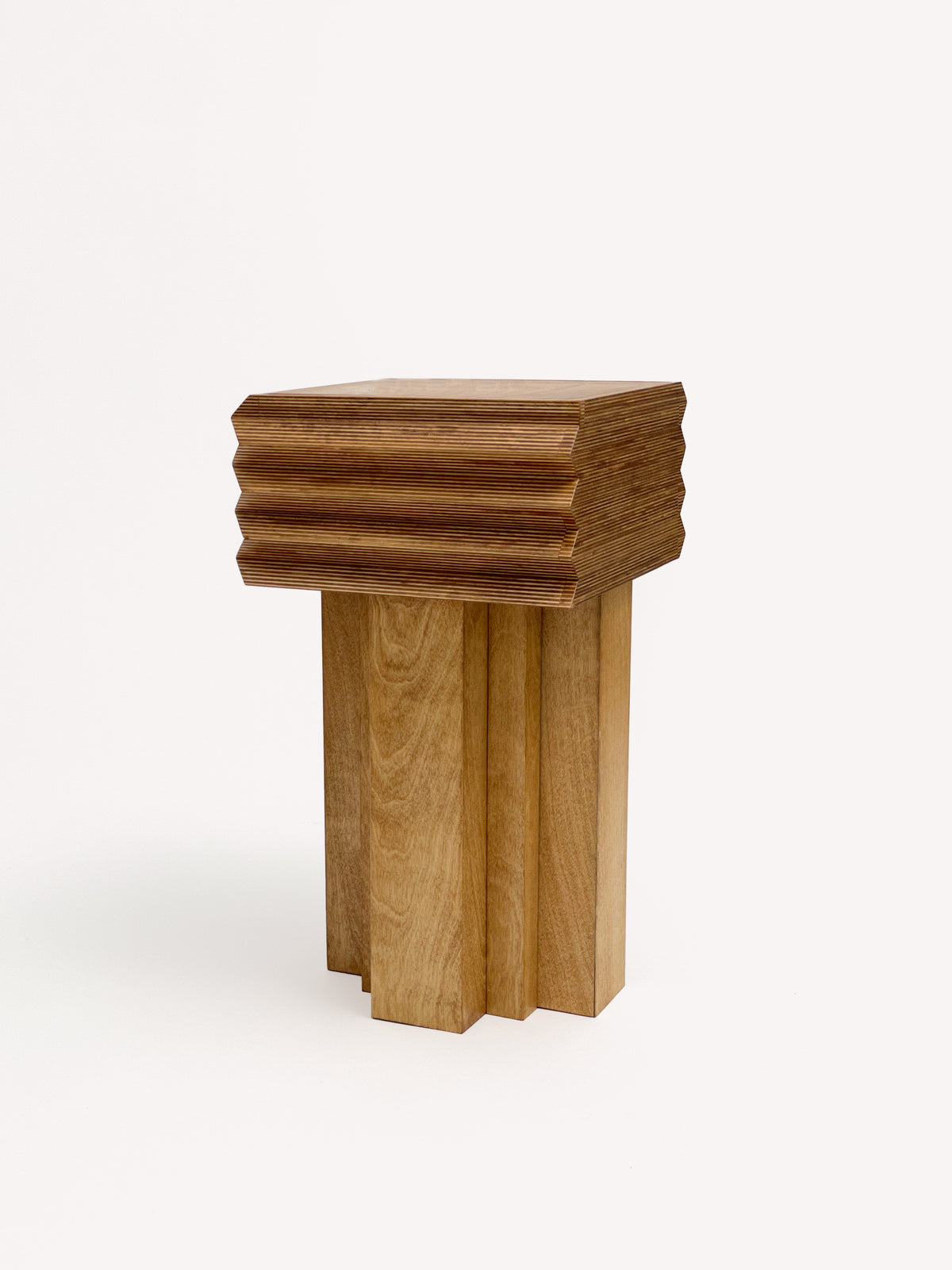 The MM Stool - Butterscotch by GOONS features a square wooden top with layered, stepped edges and block-like legs for a modern geometric look. The natural wood finish offers customizable style, showcasing the craftsmanship of GOONS.