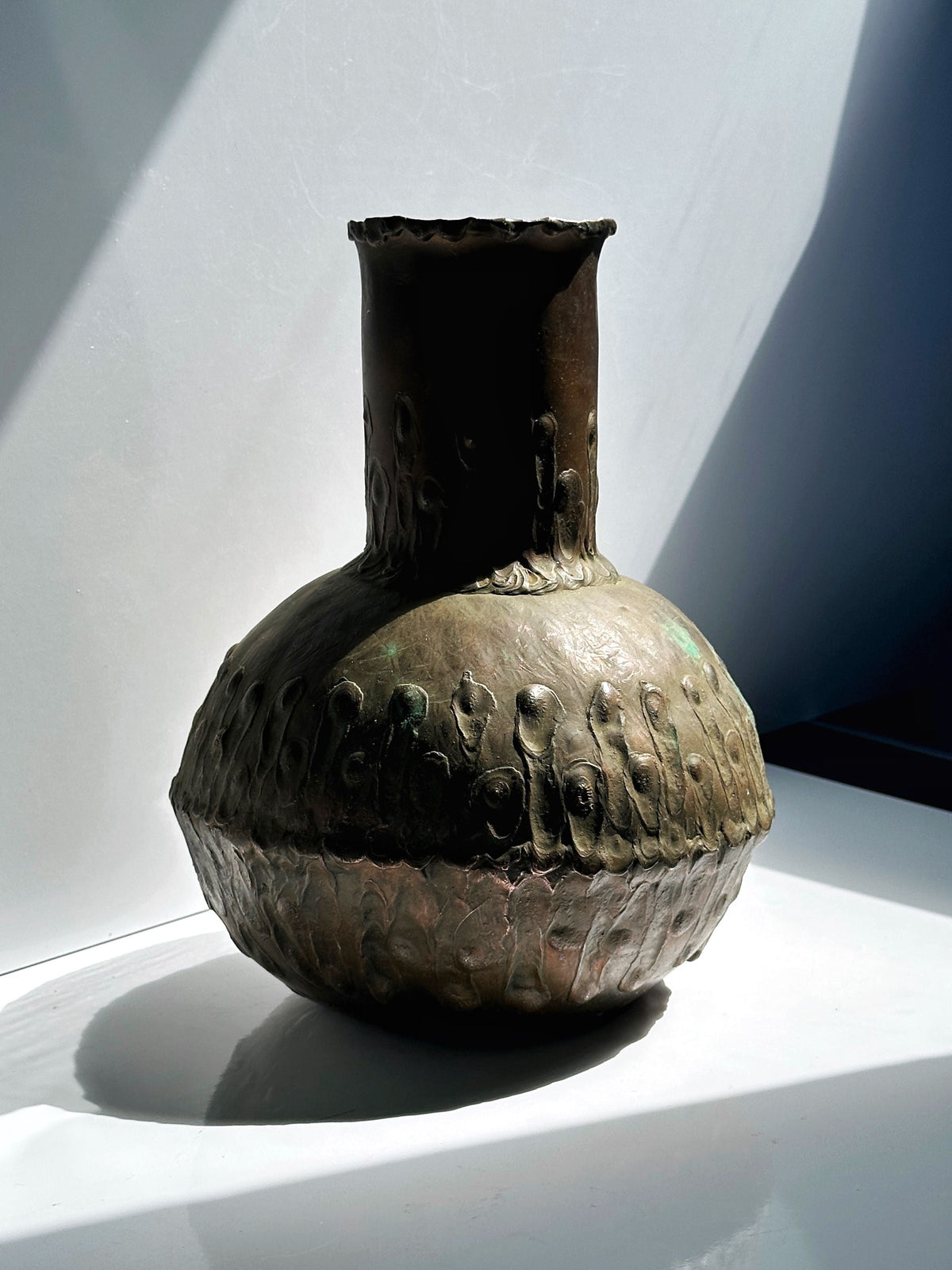 Aged copper vase showing weathered patina and textural detail