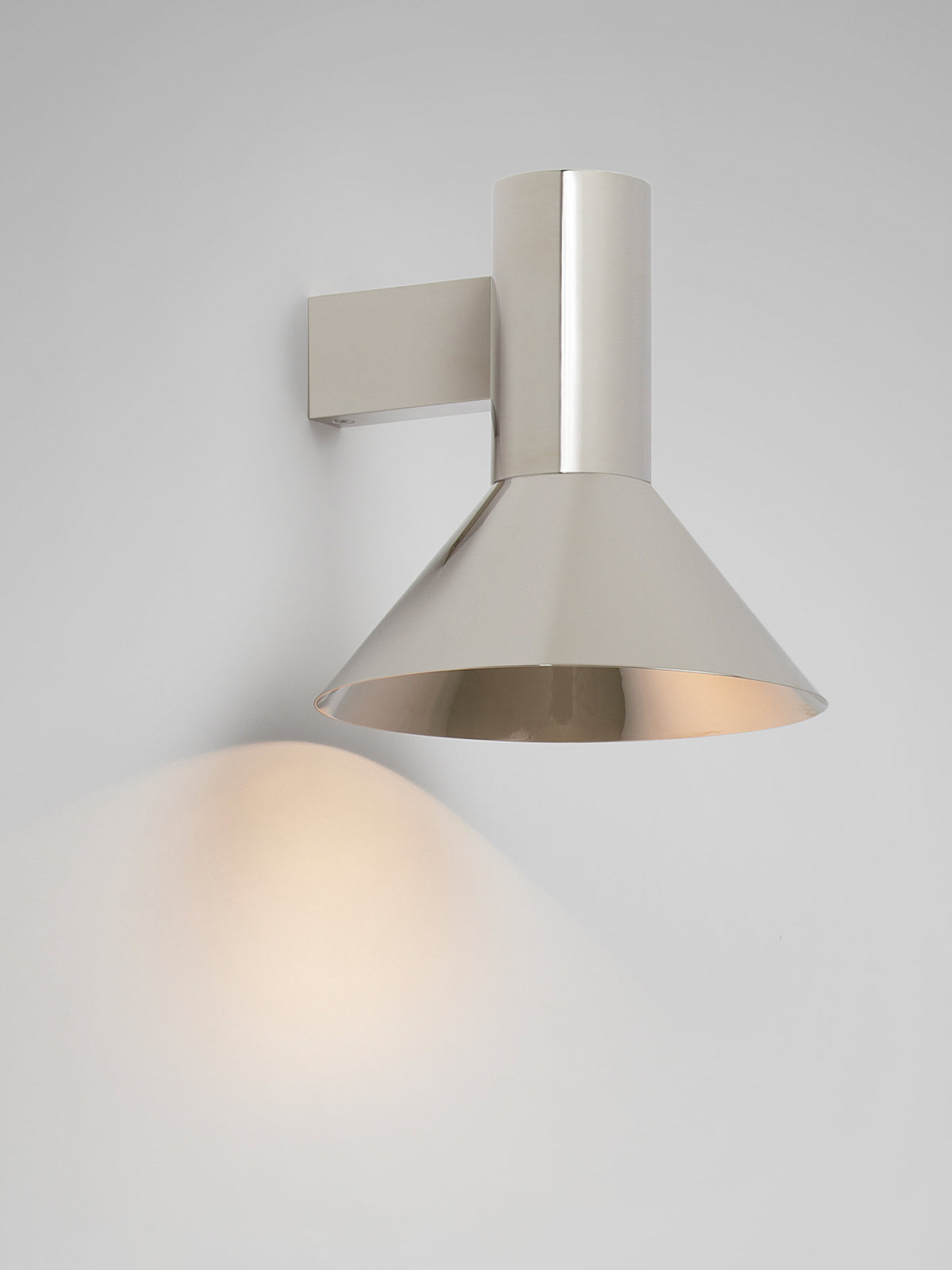 TORRES Wall — close-up of polished metal shade on wall