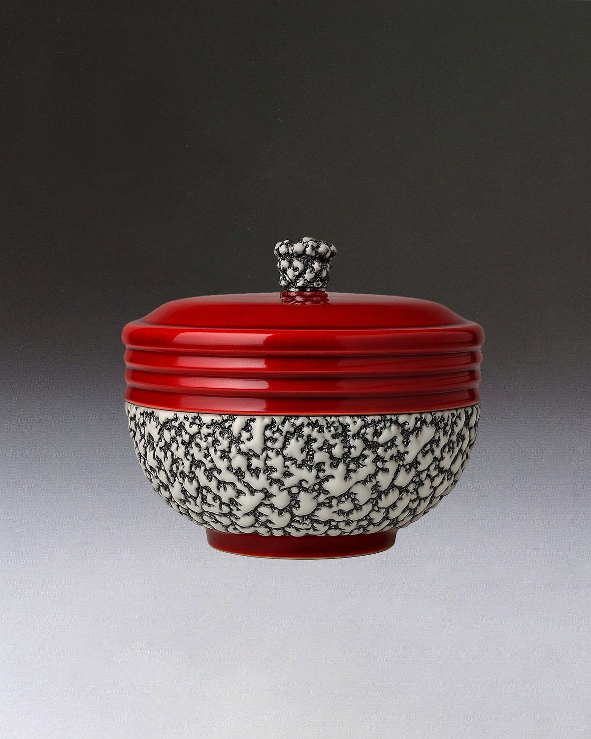 The Art Deco Ceramic Oxblood Box by Paul Millet Manufacture de Sevres from STUDIO ASAC features a white base with black branch-like patterns, a glossy red lid with knob handle, and a subtle Sevres-style gradient background.