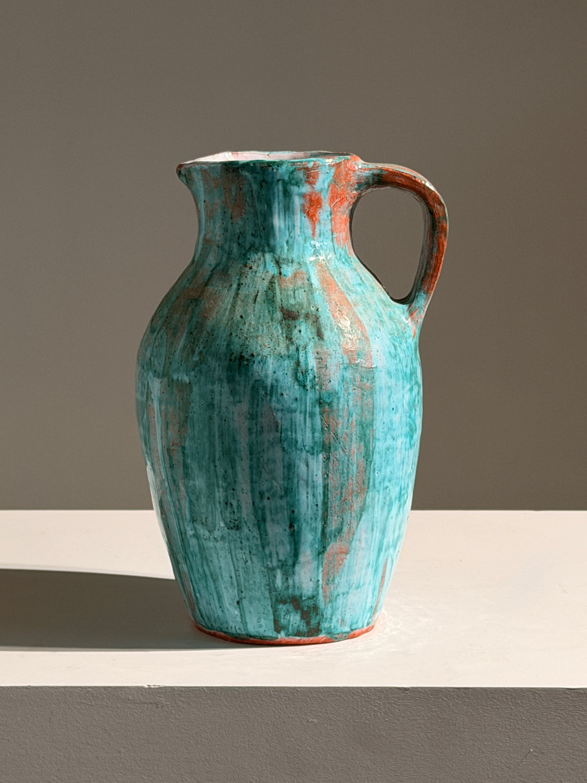 Large pitcher in green glazed earthenware, south of France, circa 1960. — side angle