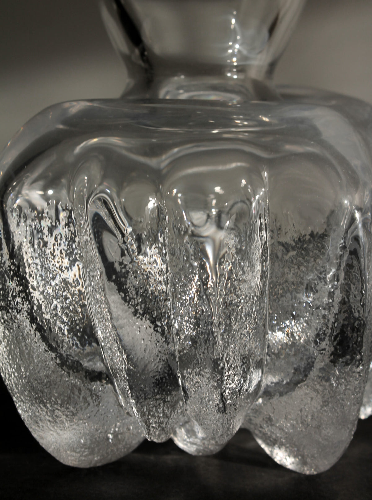 Close-up detail of crystal glass vase showing textured surface