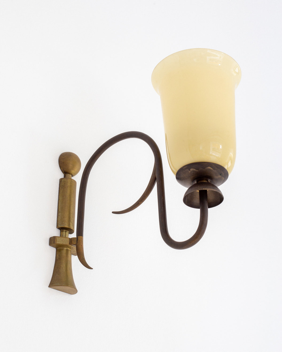 Art Deco brass wall sconce with amber glass shade detail