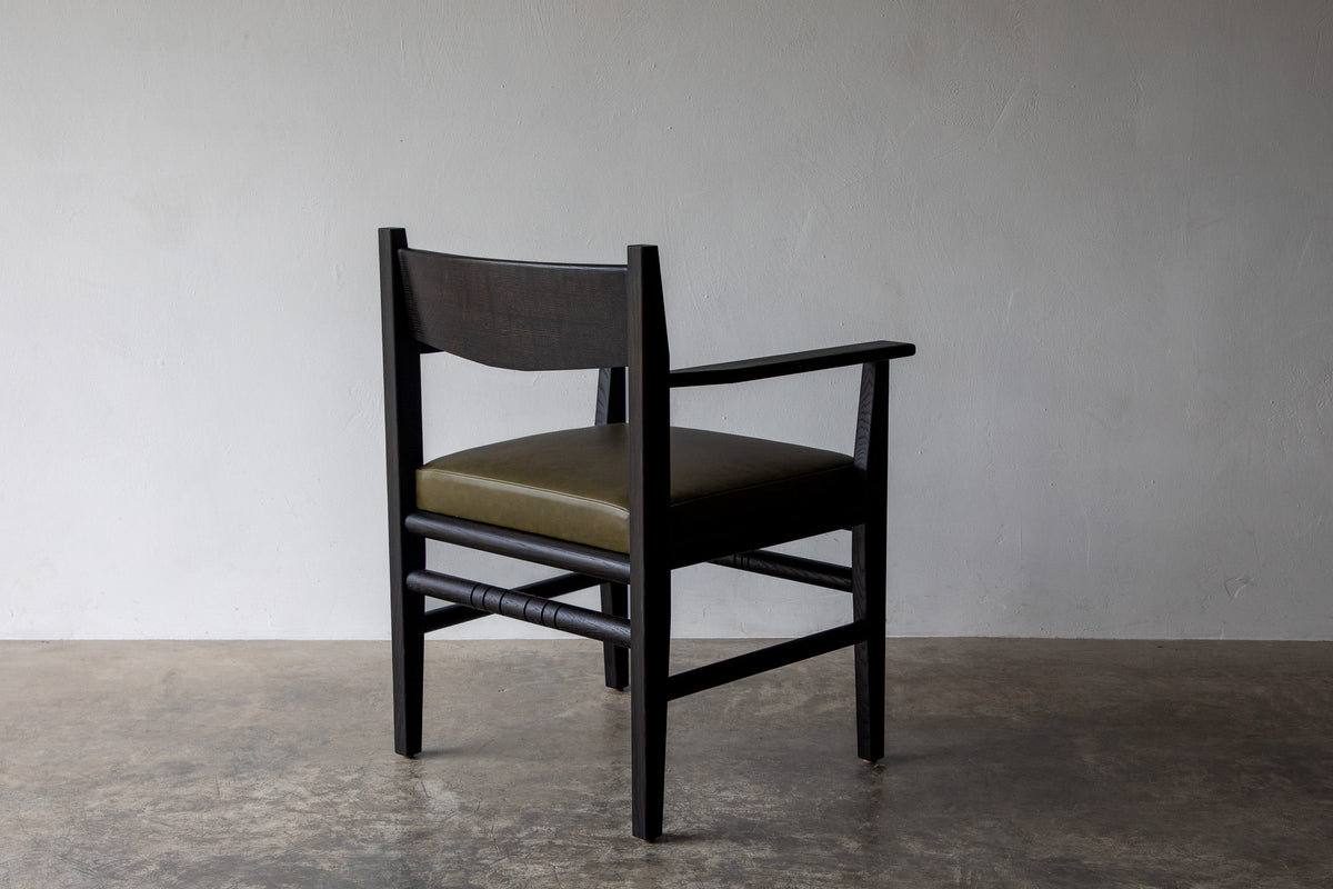 Silo Upholstered Chair — side angle with olive green seat and wooden frame
