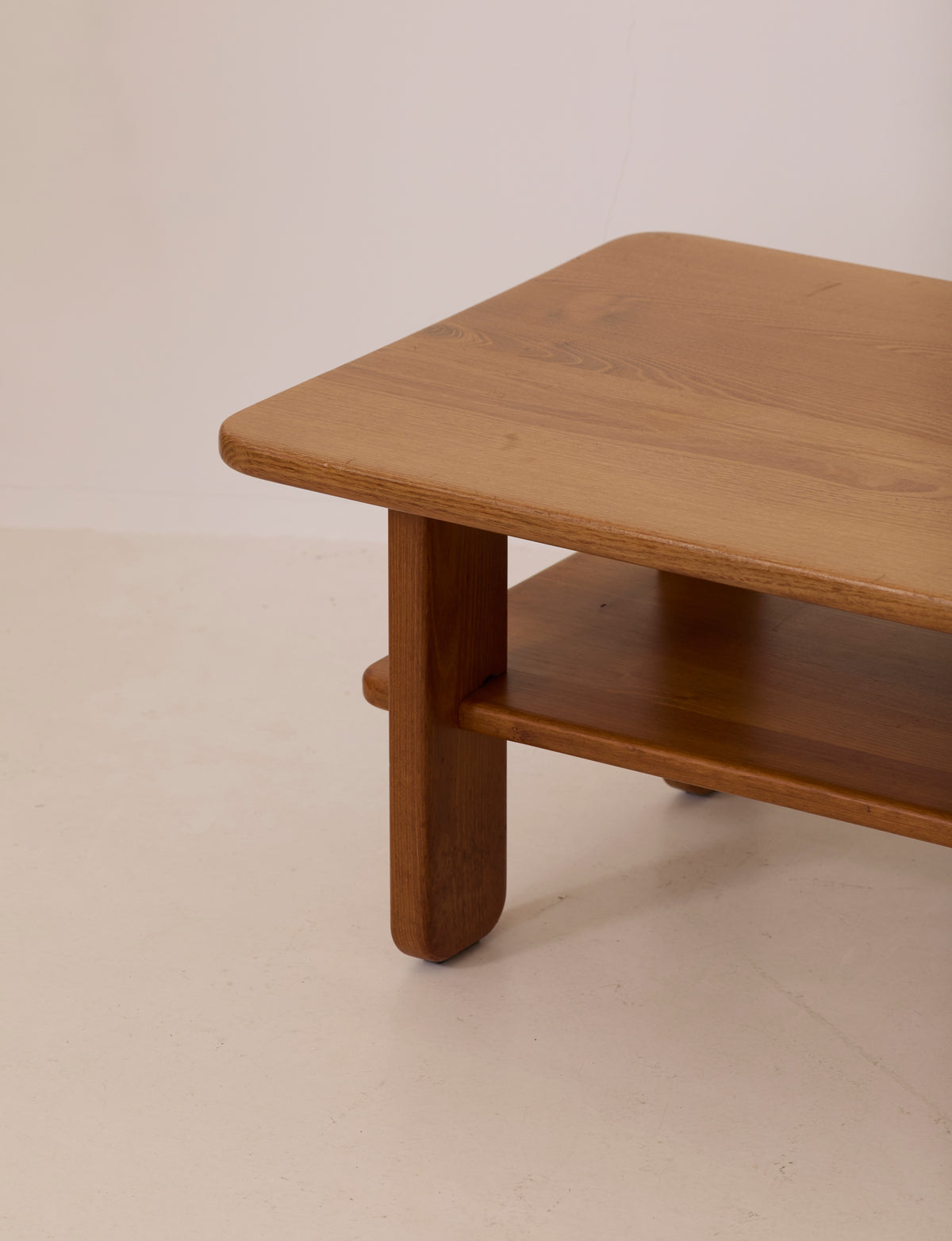 Solid elm coffee table by Alain Gaubert, France circa 1980 — side angle showing smooth wooden surface and shelf