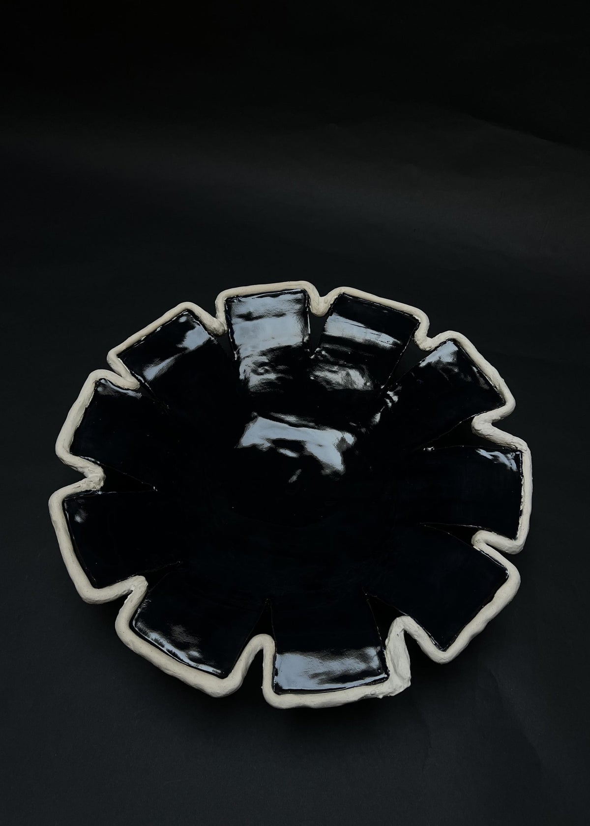 Navy blue ceramic decorative dish with geometric scalloped rim detail