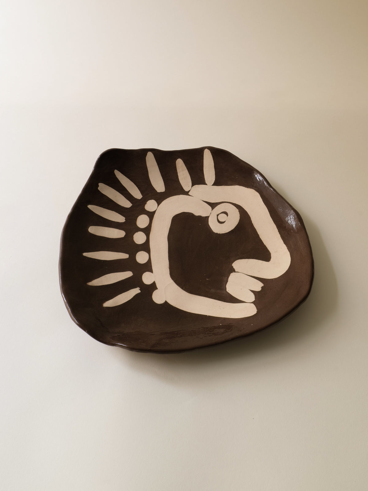 Brown ceramic plate with cream bird motif, modernist 1950s design