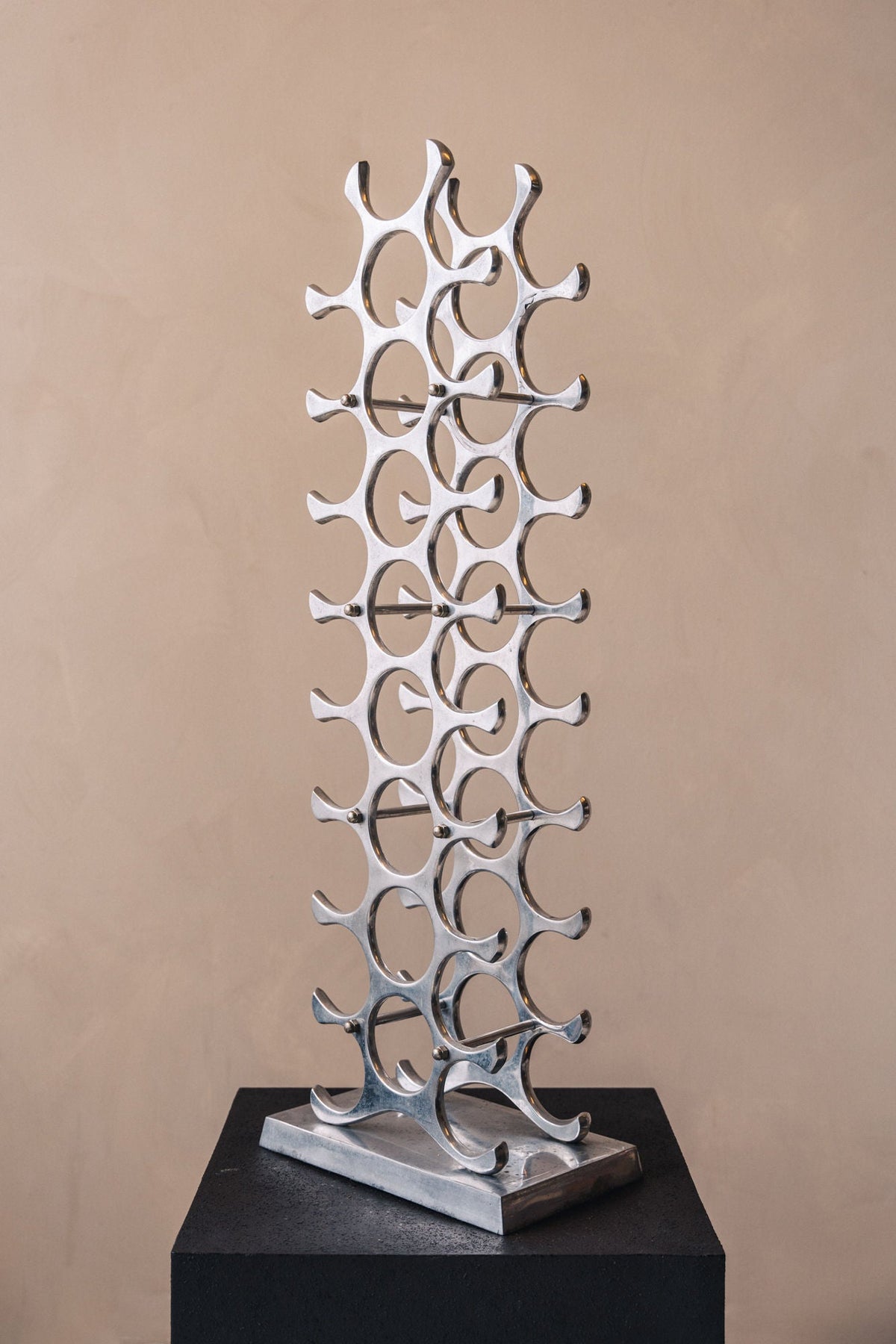 Polished aluminum wine rack tower with curved bottle holders