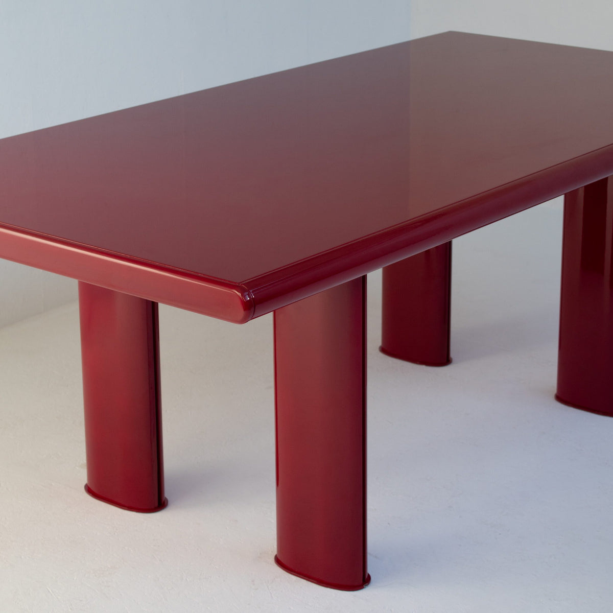 Red Lacquered Dining Table in Wood and Metal — side angle showing glossy red finish