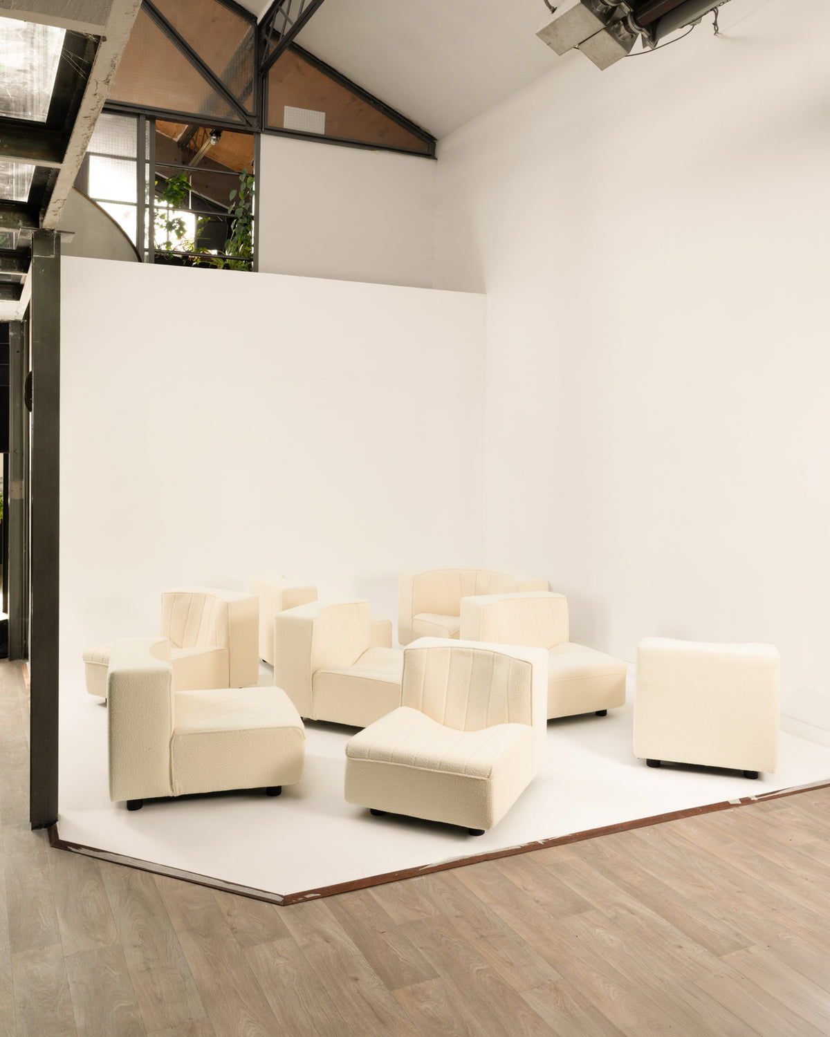 Cream modular sofa components arranged in modern loft setting