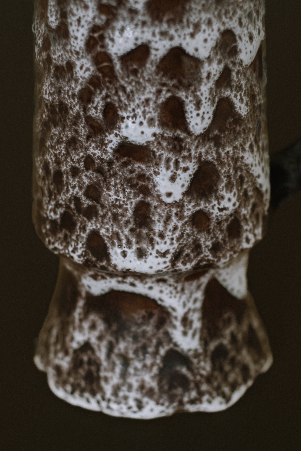 Close-up detail of handmade stoneware pitcher with speckled glaze