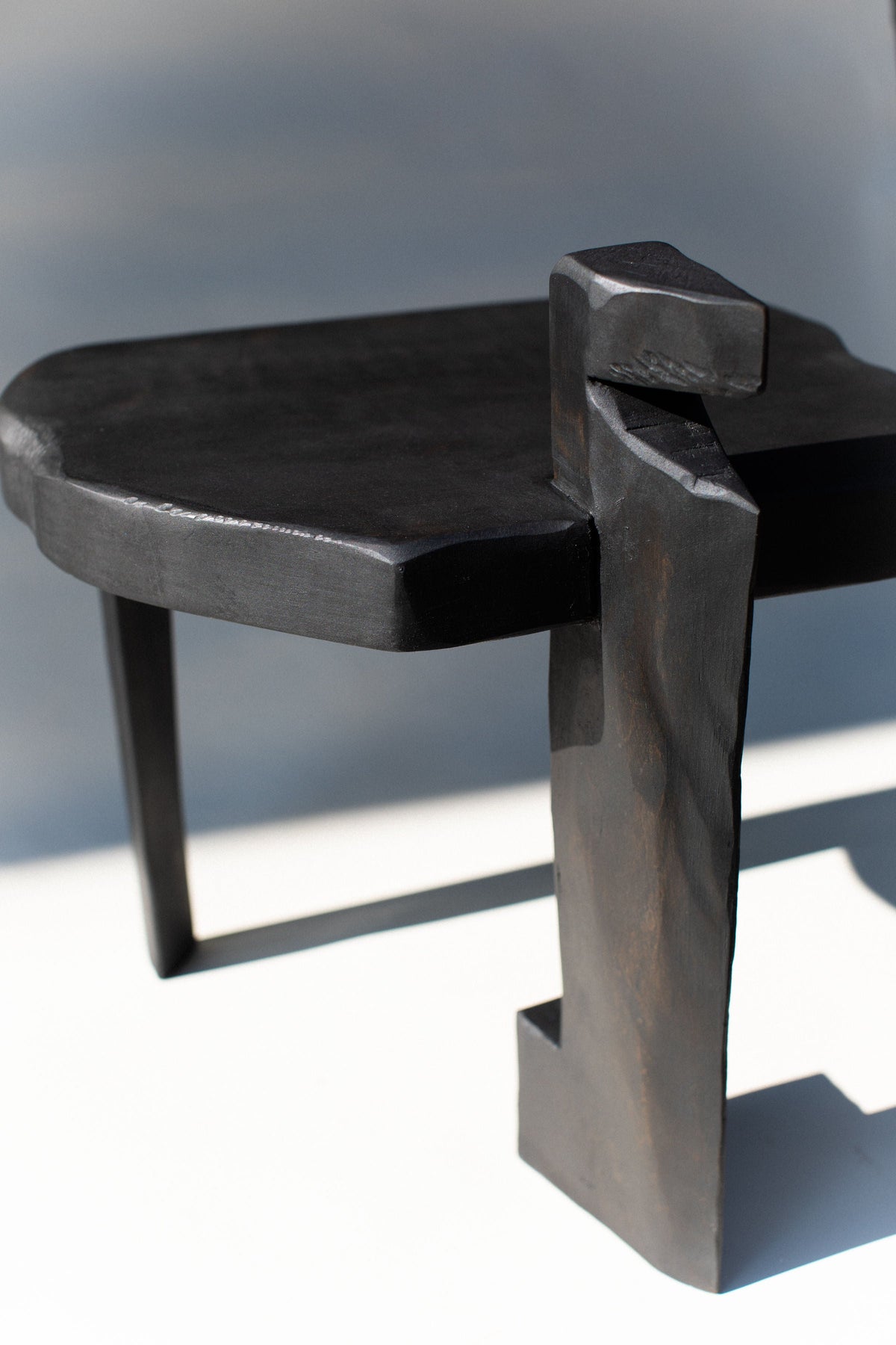 Detail view of ebony Sharie stool joint and curved backrest