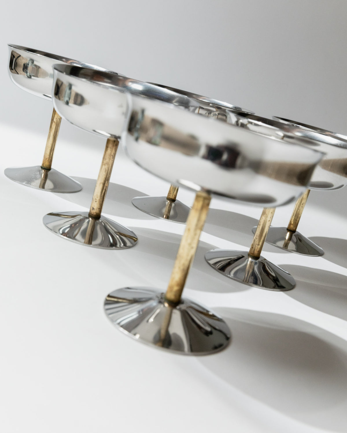 Detail view of golden stems supporting vintage champagne coupes