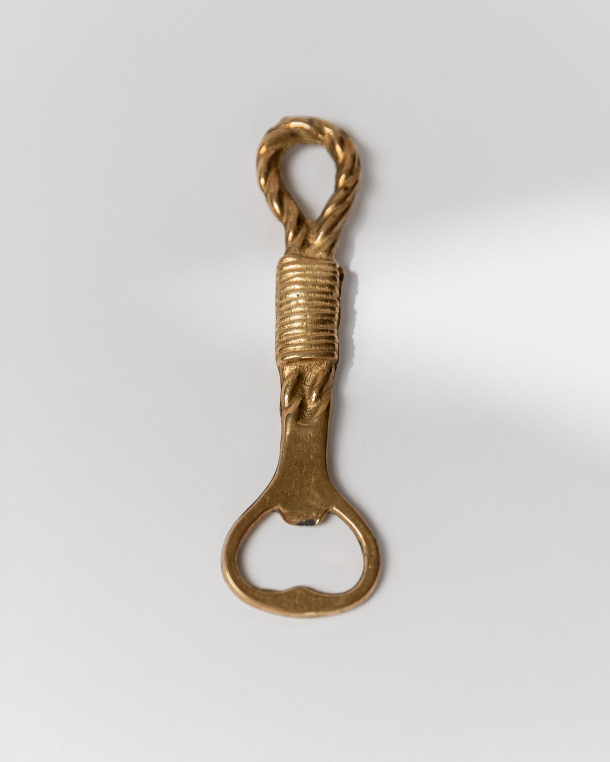 Vintage brass bottle opener with twisted rope handle detail