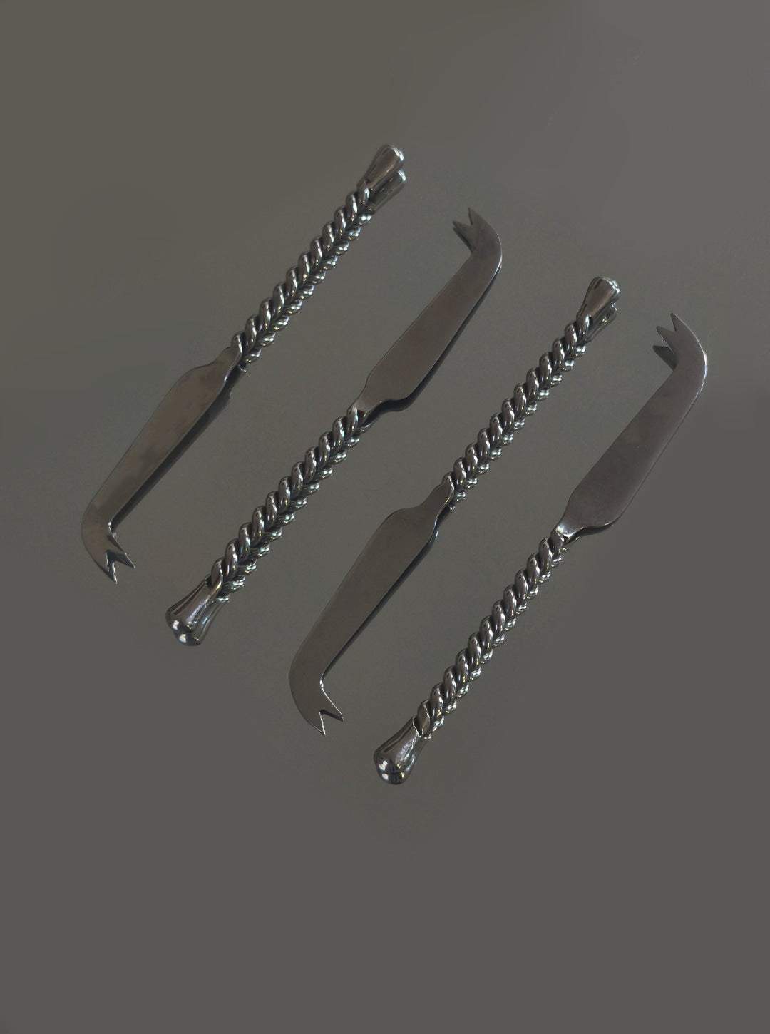 Set of 4 stainless steel cheese knives with twisted handles detail