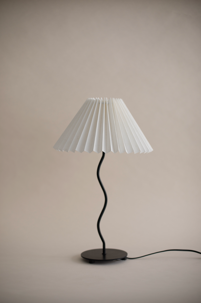 Modern table lamp with white pleated shade and curved black stem